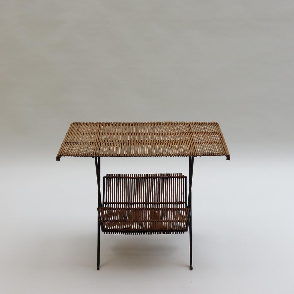 Merveilleuse table d'appoint de qualité des années 1950.  Fabriqué à partir d'une tige d'acier, qui a été formée en une merveilleuse forme sculpturale pour les pieds et le plateau cannelé, soutenu par un cadre en métal. Un porte-revues formé d'une