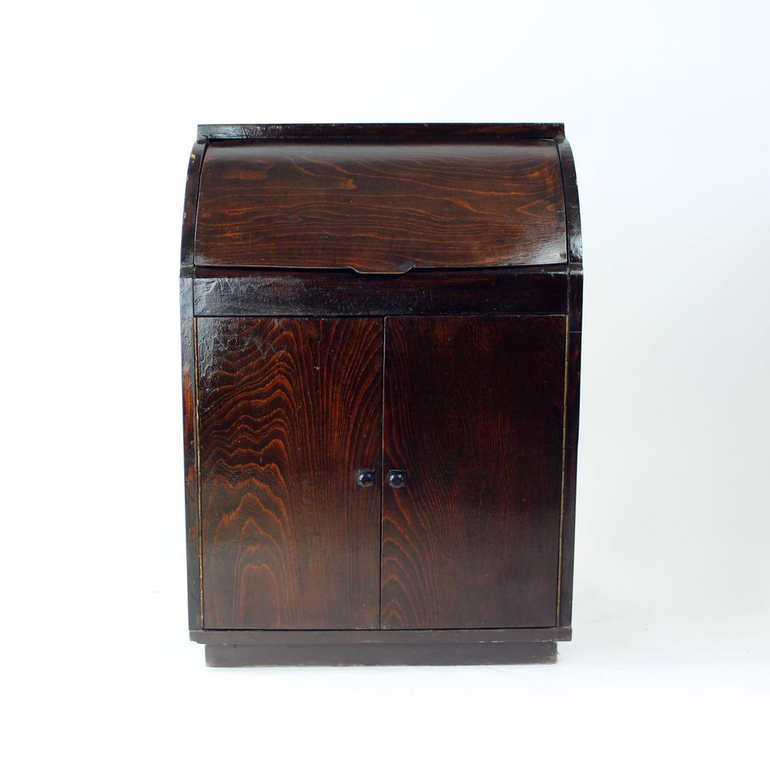 Wunderschönes Sideboard aus den 1950er Jahren, das heute problemlos als Bar genutzt werden kann. Das Sideboard ist aus Eichenholz gefertigt und hat eine stabile Konstruktion mit dunkelbraun gebeiztem Holz. Das untere Fach hat zwei glatte Türen mit