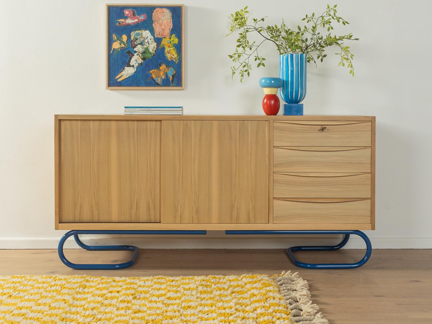Splendida credenza semi-solida in stile scandinavo degli anni '50. Corpus in impiallacciatura di noce sbiancato con due ante, un ripiano, quattro cassetti e nuovi piedini blu in acciaio inox dal design Bauhaus. Il design è attribuito allo studente