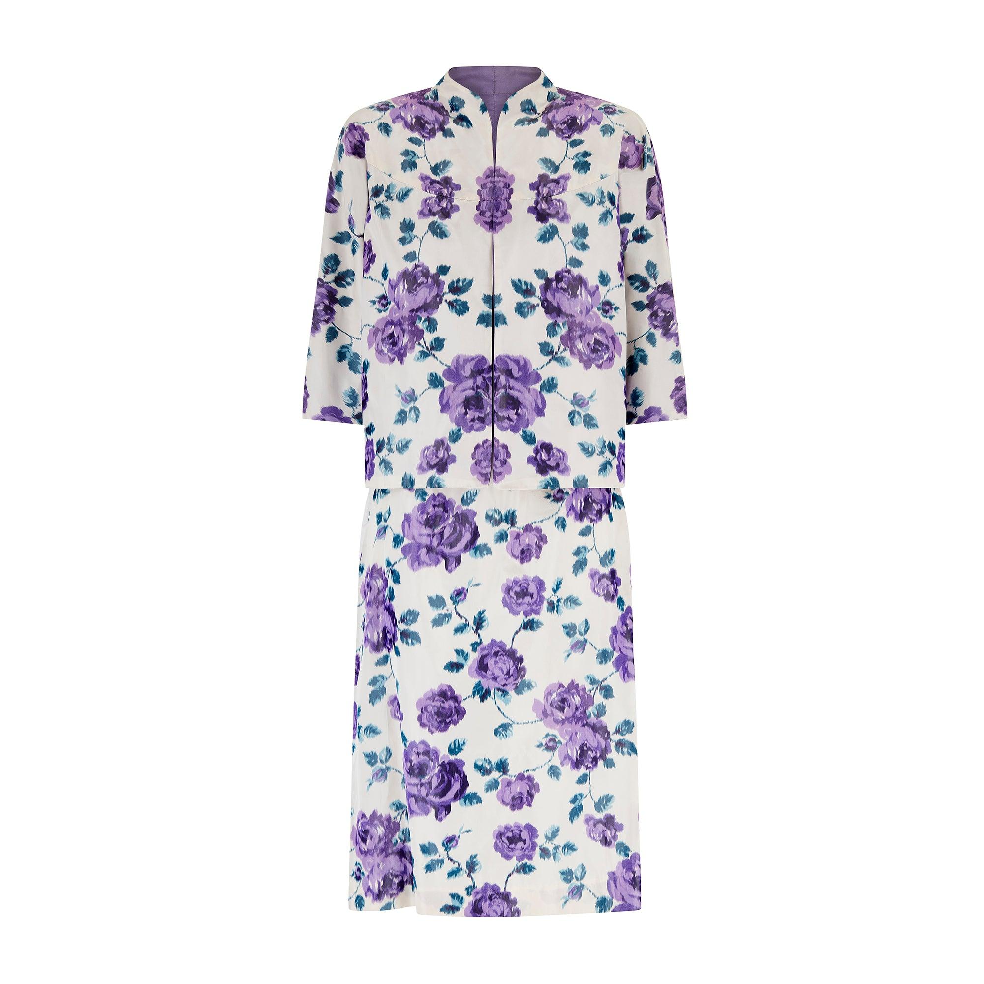 Questo abito floreale di fine anni '50-inizio anni '60 è abbinato a una giacca con collo aperto: un'accoppiata senza tempo che trasporta immediatamente chi lo indossa in quell'epoca. L'insieme è realizzato in seta spalmata di qualità finissima in