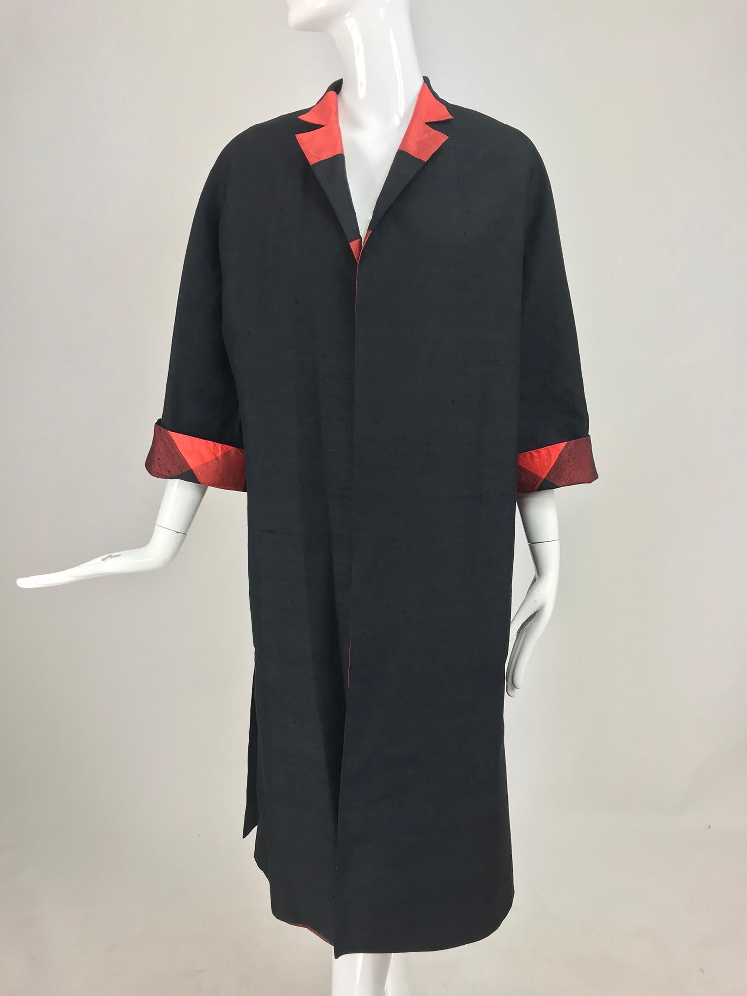 1950s Silk Shantung Reversible Coat Black and Orange Buffalo Plaid. A chic coat that can be worn two ways, the first, classic black silk shantung, the second large scale orange and black buffalo plaid. The coat is open at the front with 3/4 length