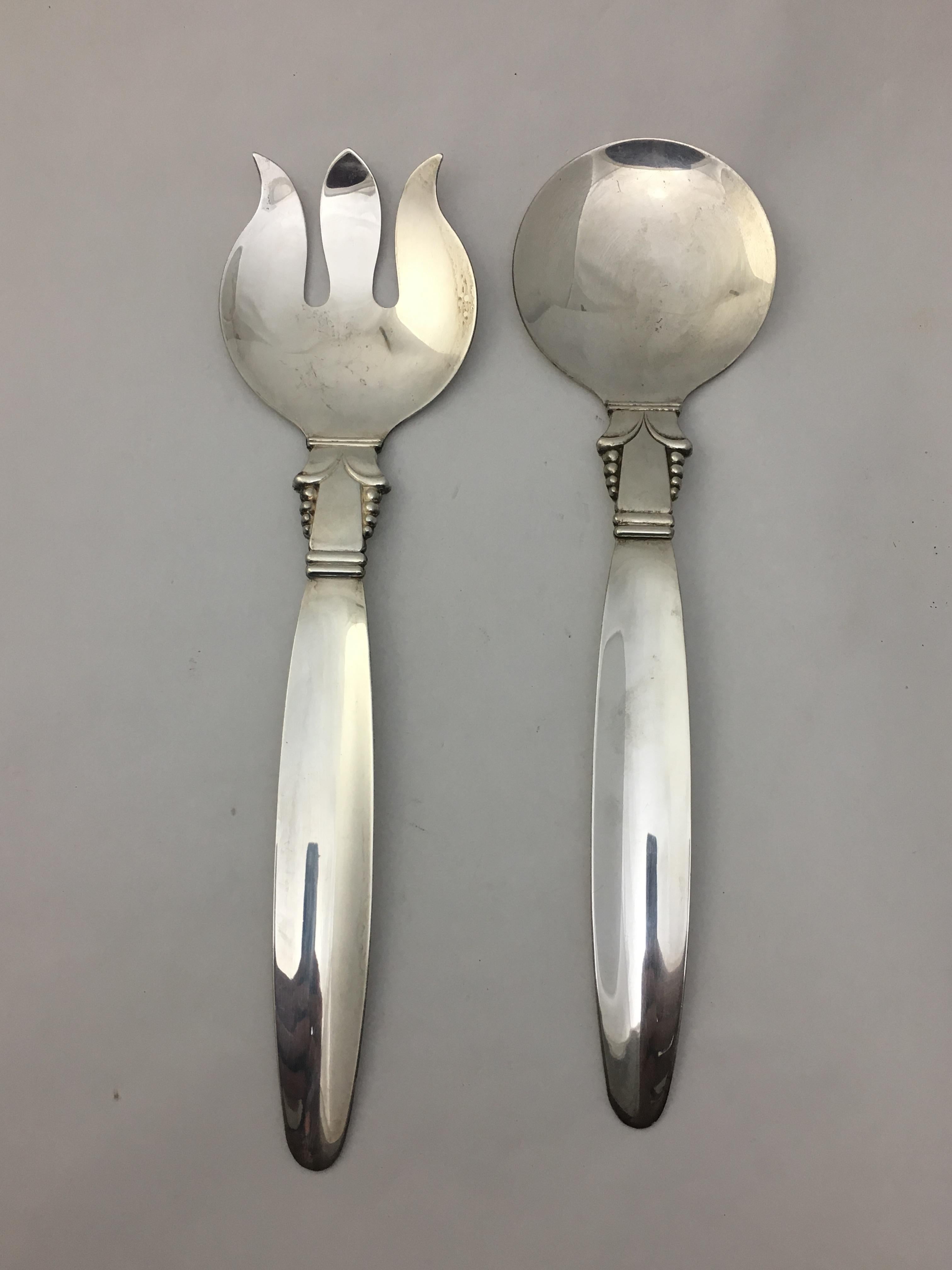 Georg Jensen style silver plate on copper modern serving fork and spoon, circa 1950. Signed on back, Original by A.L., silver/copper. Very good condition.

The fork measures 12.25