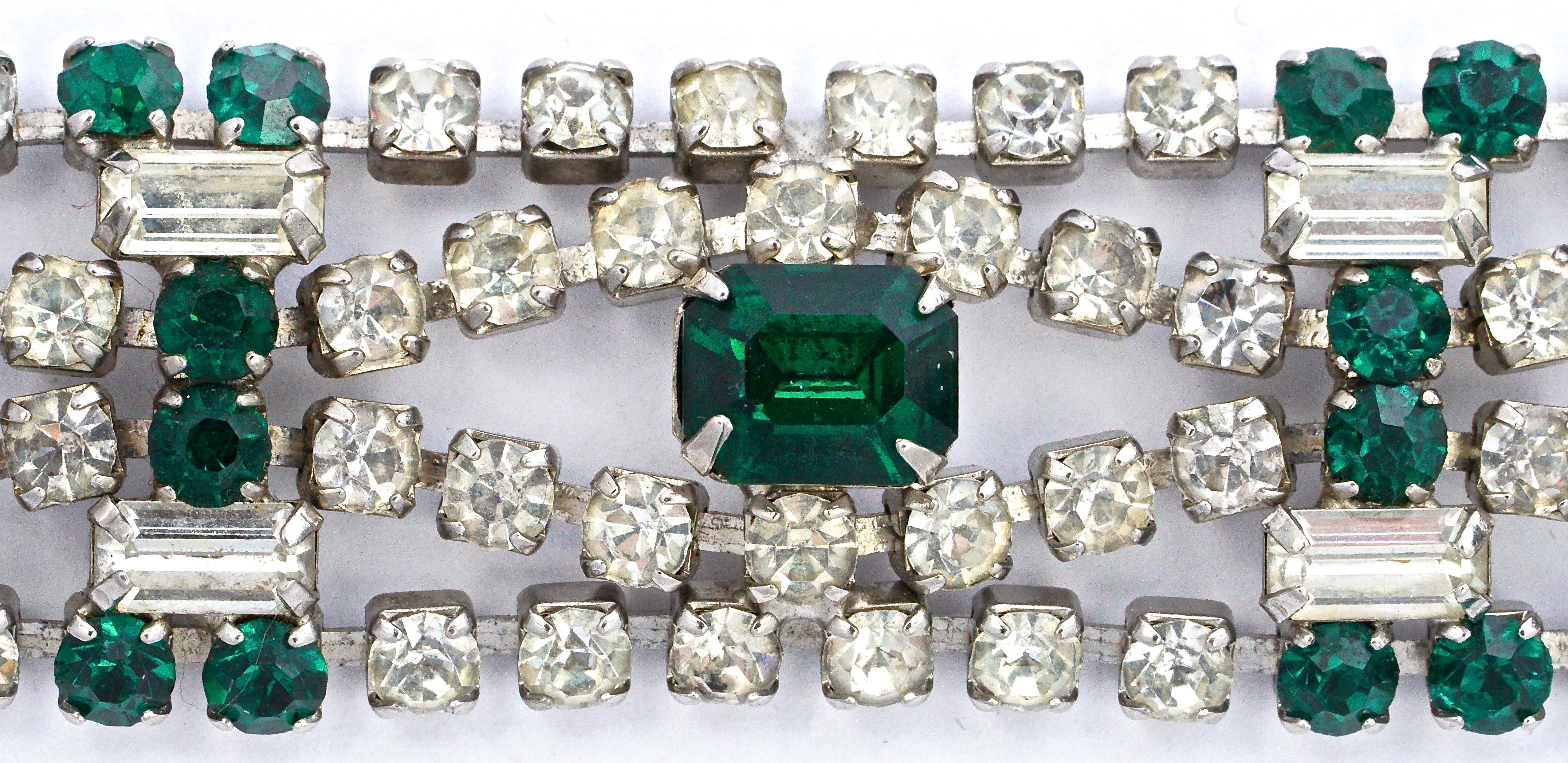 Beautiful silver tone bracelet featuring faceted emerald green and clear rhinestones, with a fold over clasp. The bracelet is slightly curved, and is in very good condition with all the original stones, circa 1950s. At a later date, the bracelet has