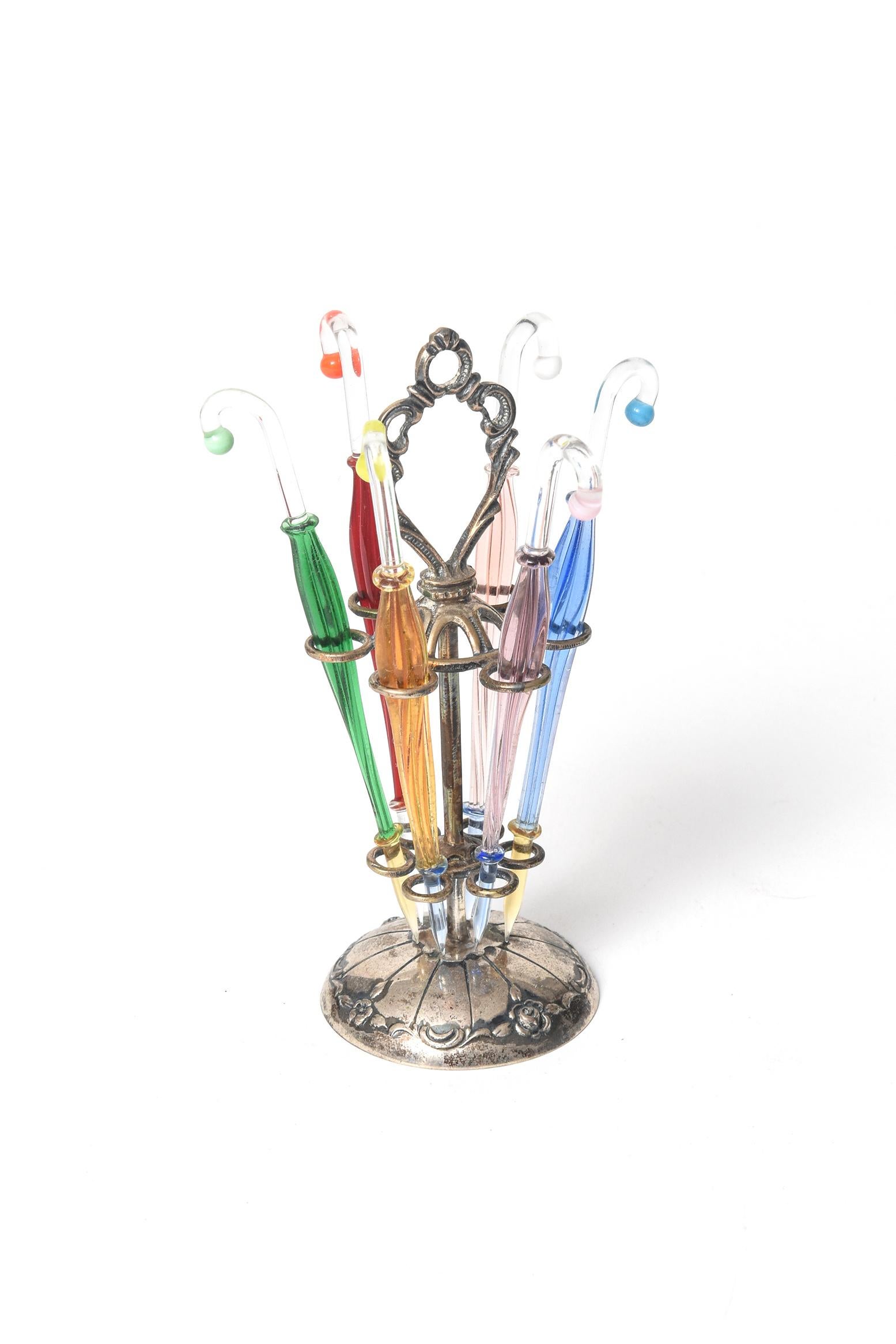Vintage 1950s cocktail pick set featuring six handblown colorful umbrella cocktail picks held in a delicate silver floral umbrella stand. Perfect for martinis or any other cocktail that require a garnish. They could also be used for horderves. The