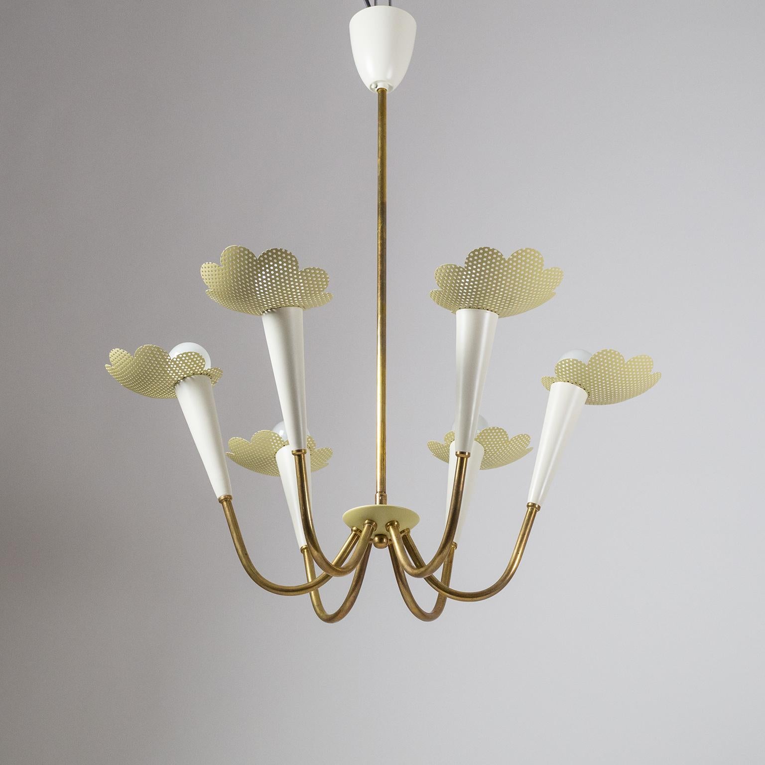 Delightful modernist chandelier from the 1950s. Six brass arms, each with an off-white lacquered socket cover and a pastel-mustard colored pierced floral shade. The brass parts have a lovely vintage patina, while the lacquered parts have been