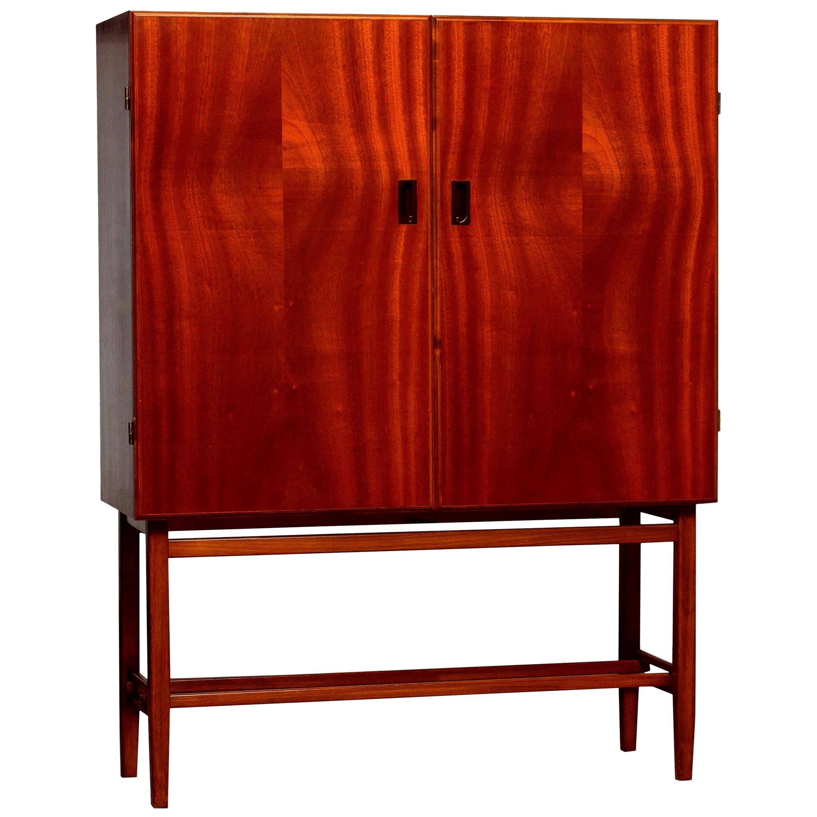 Beautiful dry bar or cabinet in mahogany made in Sweden, by Forenades Mobler of Linkoping, 1950s.
Equipped with two doors with behind two drawers and two adjustable shelves.
Standing on slim and tall legs.

The overall condition is very good.