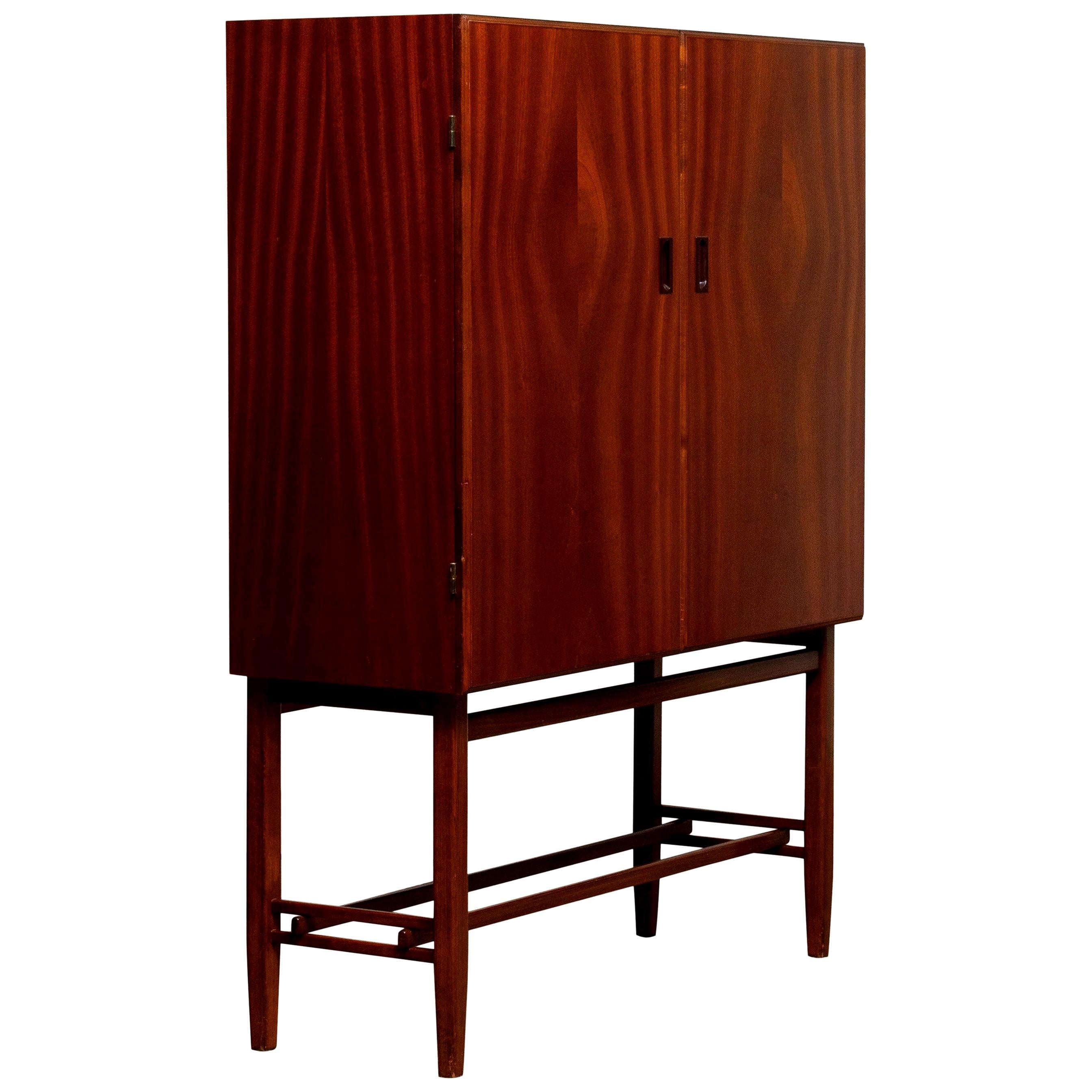 Beautiful dry bar or cabinet in mahogany made in Sweden, by Forenades Mobler of Linkoping, 1950s.
Equipped with two doors with behind two drawers and two adjustable shelves.
Standing on slim and tall legs.

The overall condition is very good.