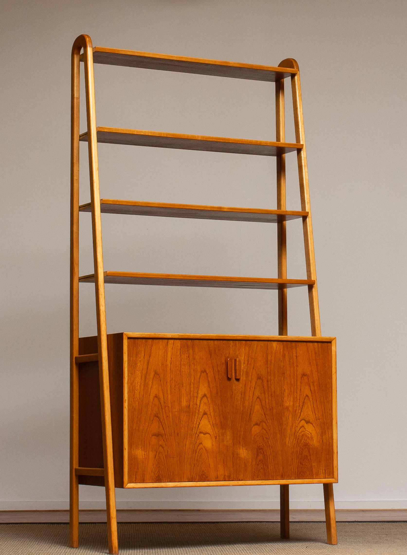 Beautiful and typical Swedish slim bookcase / shelfs cabinet in teak in combination with beech stands made by Brantorps, Sweden.
This cabinet consists four shelfs in which three are adjustable. The top shelf is fixed.
There is also an adjustable /
