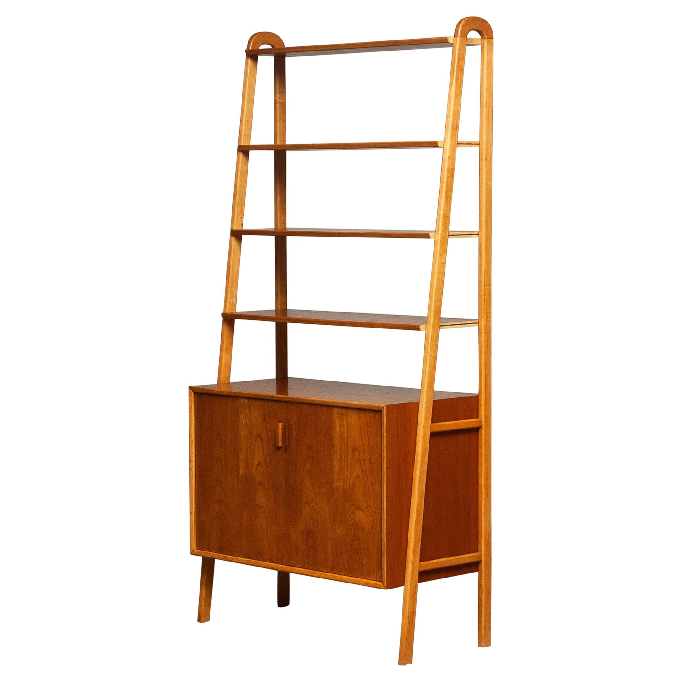 Beautiful and typical Swedish slim bookcase / shelfs cabinet in teak in combination with beech stands made by Brantorps, Sweden.
This cabinet consists four shelfs in which three are adjustable. The top shelf is fixed.
There is also an adjustable /