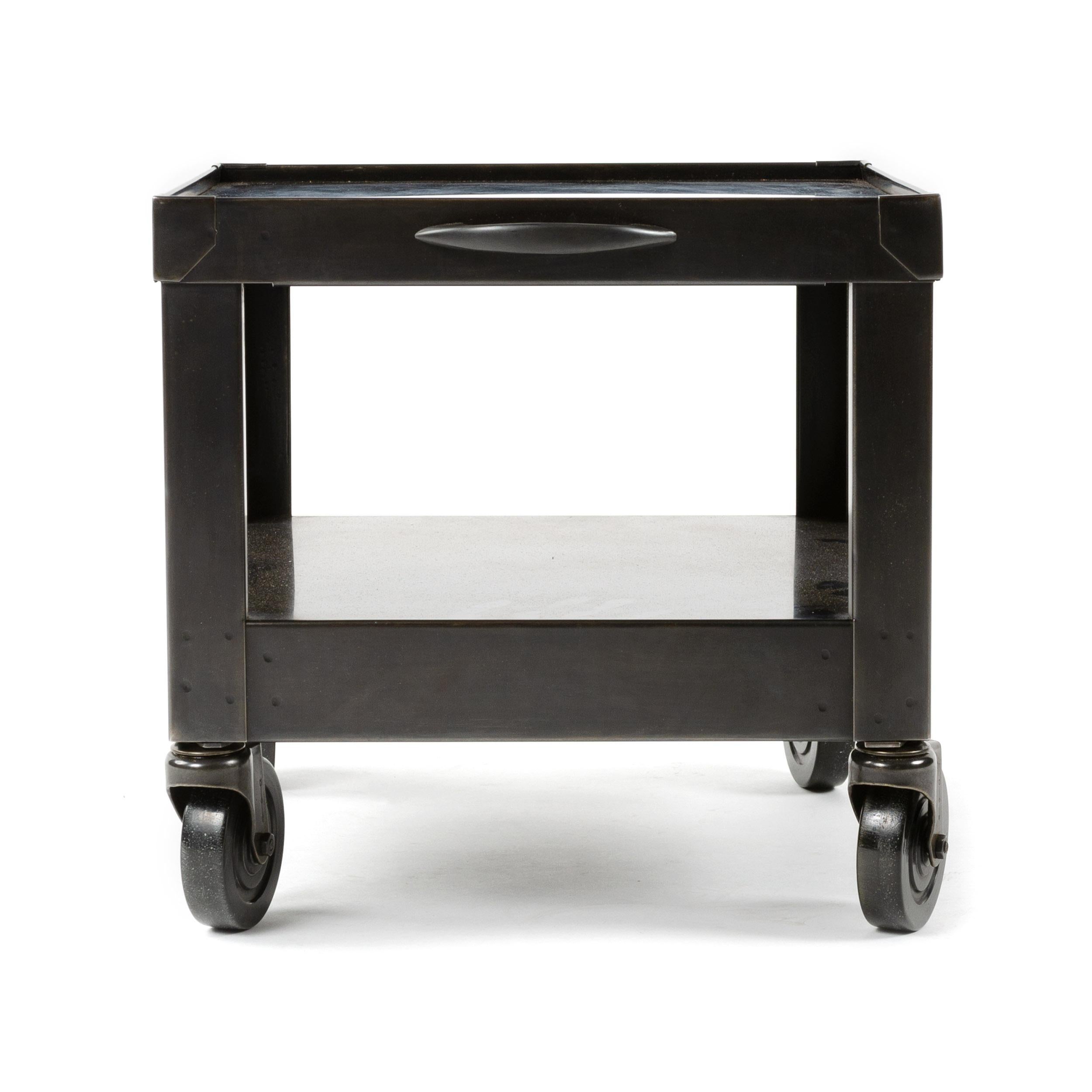 A restored and patinated industrial cart on casters with a lipped edge and handle.