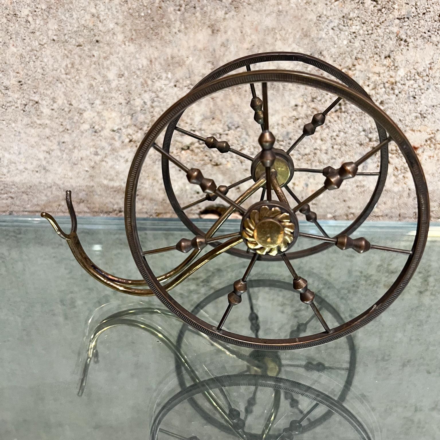 1950s Decorative Small Wine Bottle Holder Cradle Spoke Wheel in Sculptural Brass from Italy circa 1950s
5.25 tall x 3.5 w x 7.25 inches
All patinated brass. Stamped MADE in ITALY.
Original Unrestored preowned vintage condition. Patina