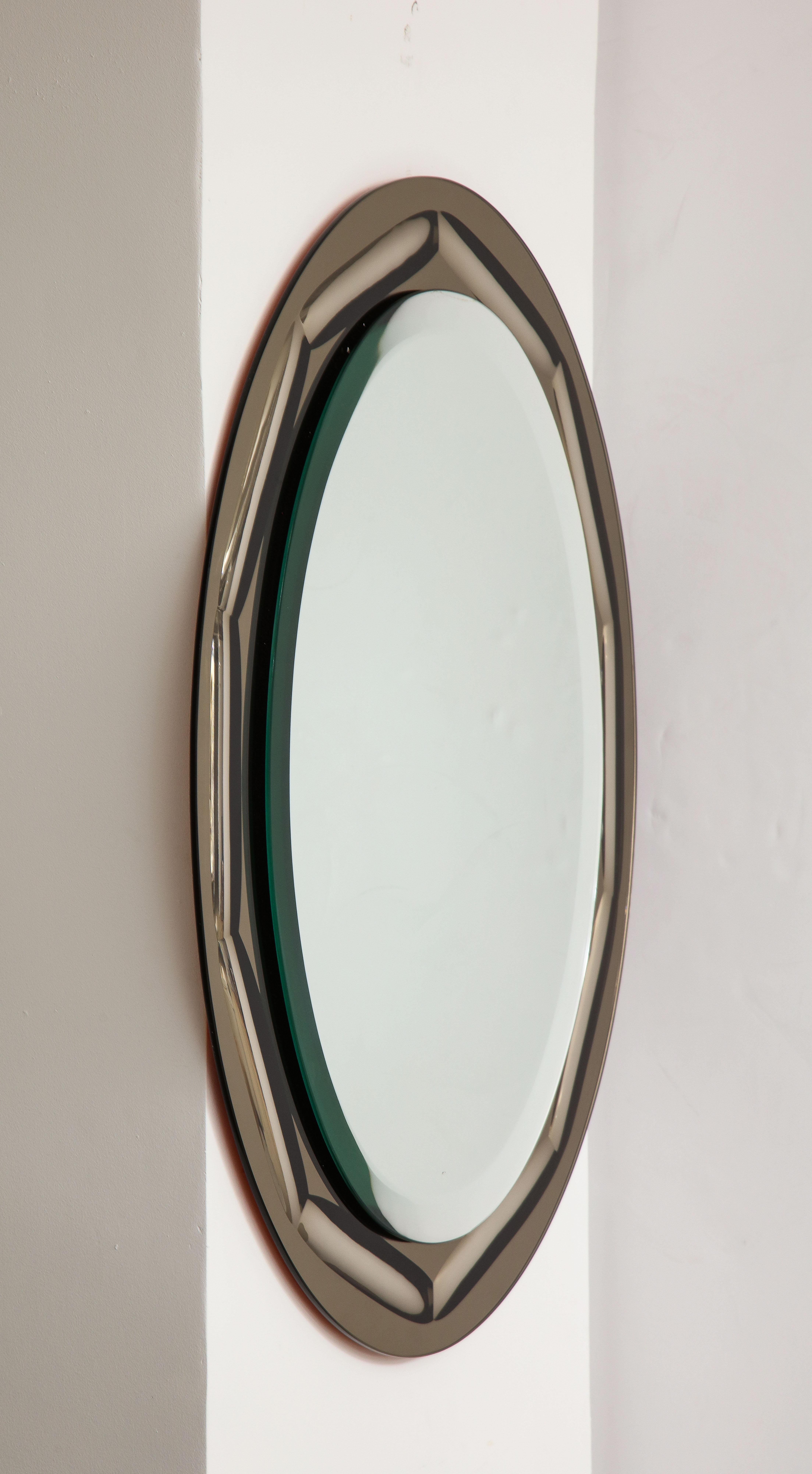 1950's Mid-Century Modern smoke glass with beveled edges Italian wall mirror, in vintage original condition with minor wear and patina due to age and use.
