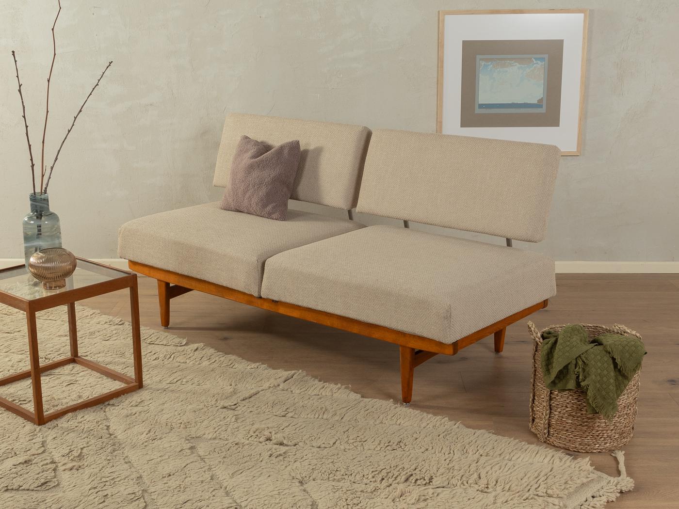 Wonderful sofa from the 1950s. High-quality solid beech wood frame. The sofa can be transformed into a guest bed in just a few simple steps. The original spring core has been reupholstered and covered with a high-quality upholstery fabric in beige.