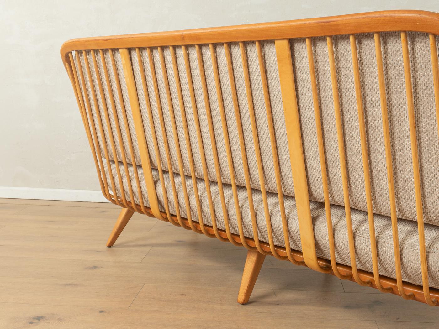 Einzigartiges Sofa von Wilhelm Knoll aus den 1950er Jahren. Massives Gestell aus Kirsche mit dekorativen Streben in den Armlehnen und im Rückenteil. Der originale Federkorb wurde neu gepolstert und mit einem hochwertigen Polsterstoff in Beige