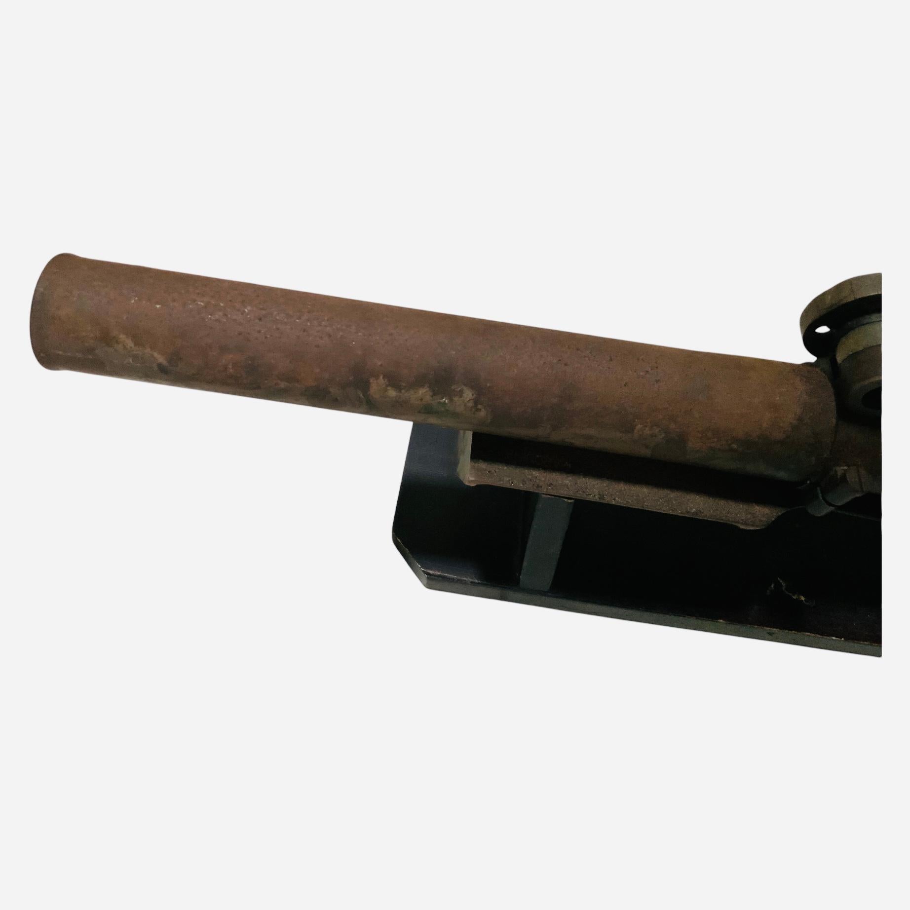 Se trata de un Mortero de la Armada Española de 1950. Representa un largo barril cilíndrico de metal oxidado sostenido por un soporte rectangular en forma de mesa de metal con dos paredes planas rectangulares en cada extremo que están unidas a una
