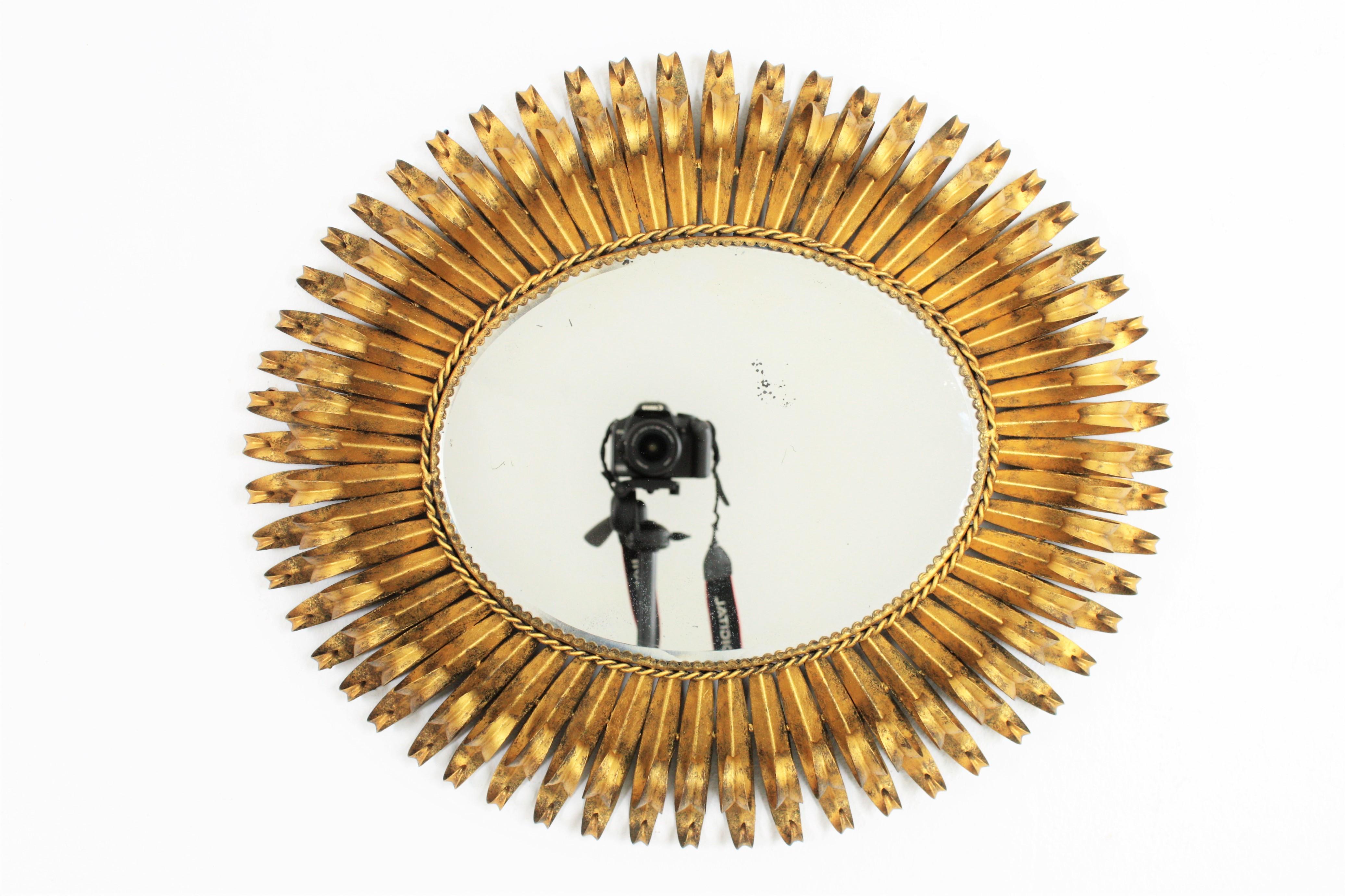 Beautiful hand-hammered Brutalist gilt iron oval shaped sunburst mirror with a highly articulated double layered eyelash frame. It can be placed in two positions, Spain, 1950s.

 
 