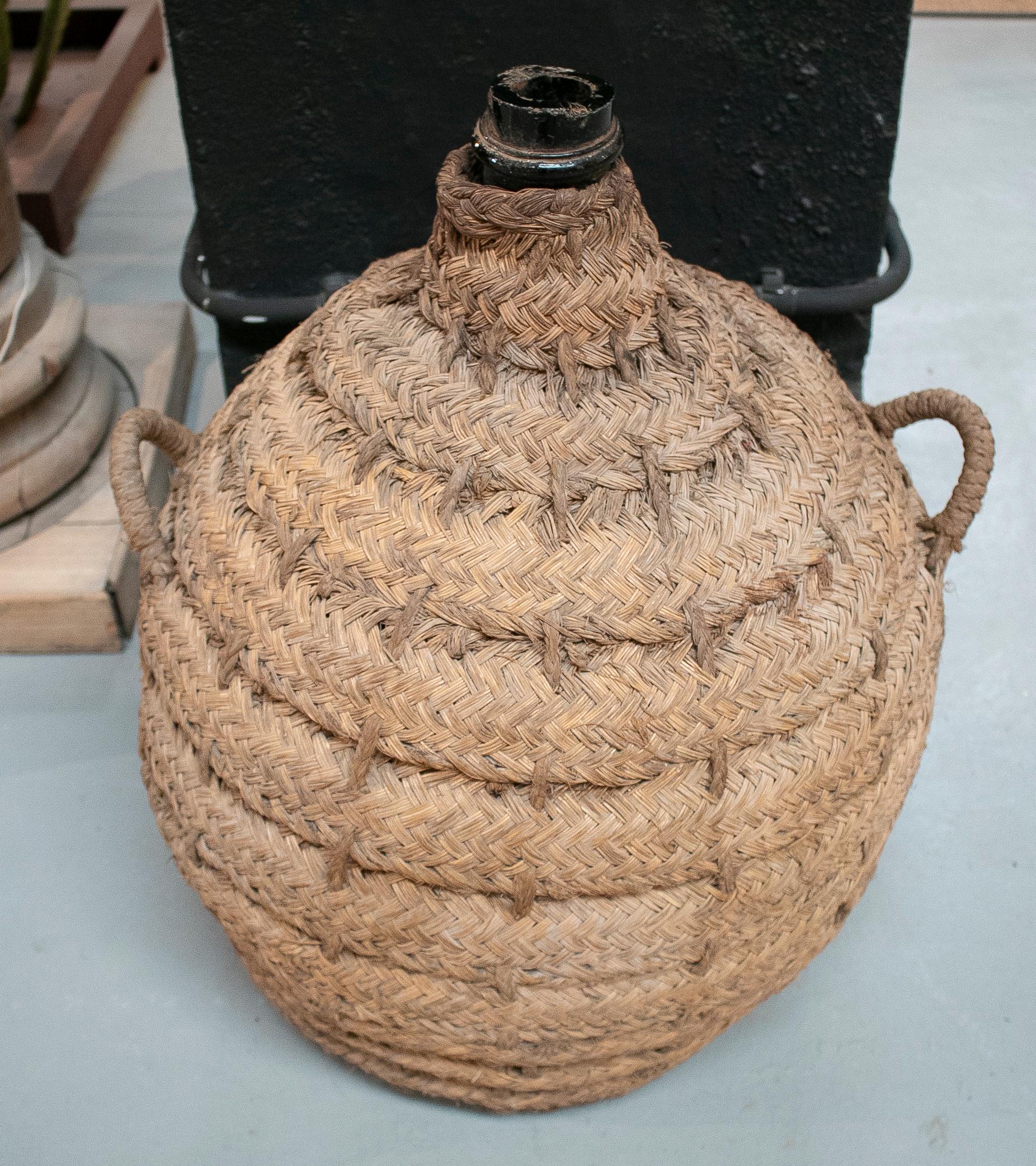 1950s Spanish glass demijohn in hand woven esparto grass basket.
