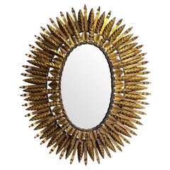 Miroir espagnol des années 1950 en fer forgé, ovale, éclairé par le soleil.