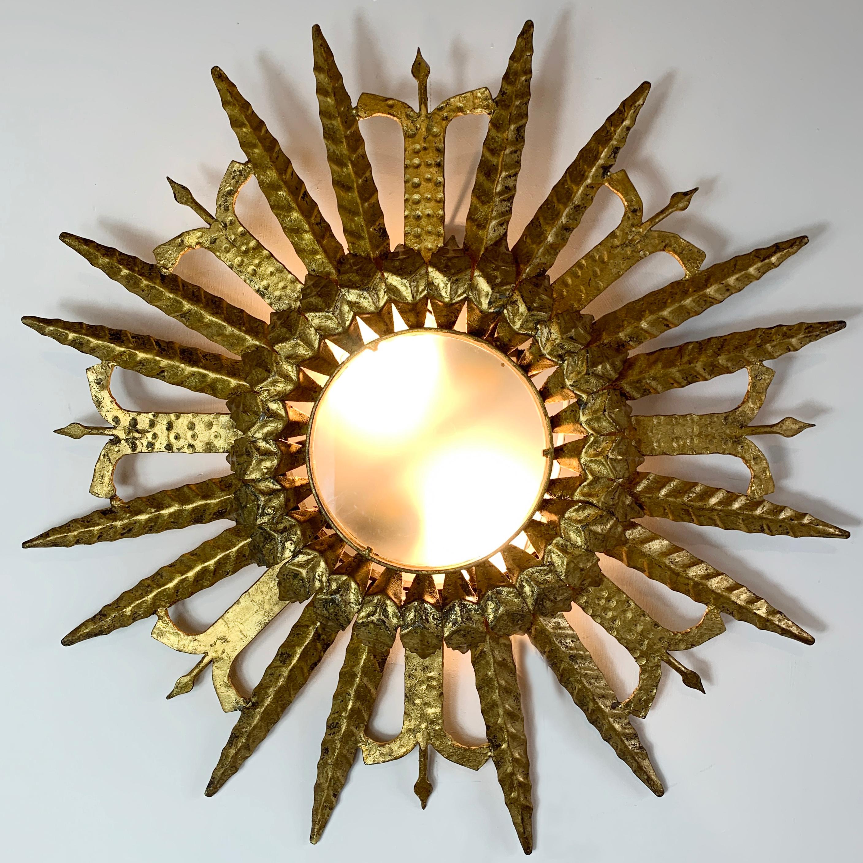 Spanische Deckenleuchte aus vergoldetem Eisen mit Sonnenschliff aus den 1950er Jahren

Ein unglaublicher spanischer Sonnenaufgang aus vergoldetem Eisen mit zwei Lampenfassungen hinter dem undurchsichtigen Glas 

Dies ist ein wirklich