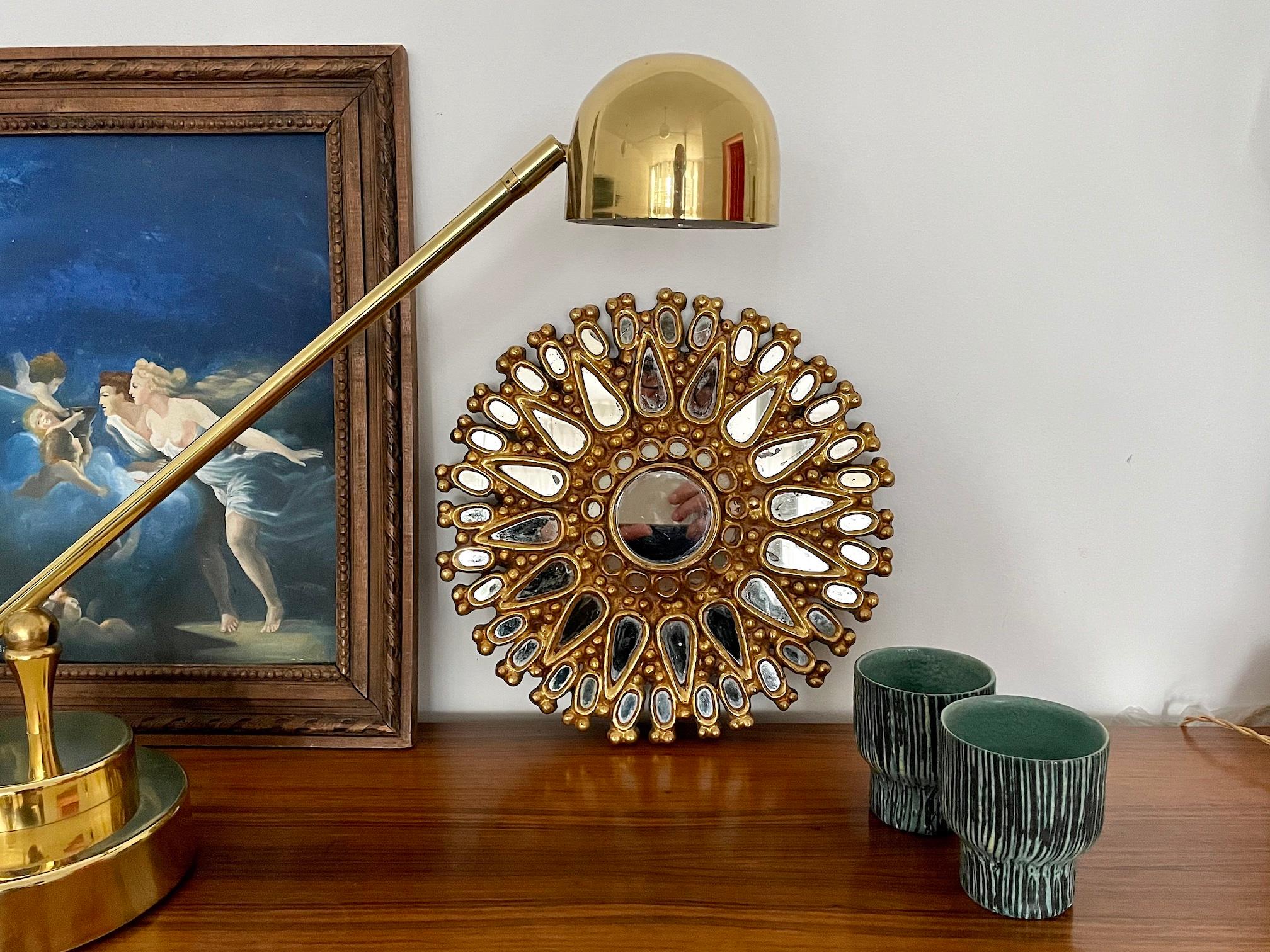 A charming mid-century century vintage Spanish sunburst wall mirror with ornamental carved details in giltwood brass. 
Makes a beautiful decorative piece that will add livelihood to your interior. 
Spain, Circa 1950's. 

    

We are an