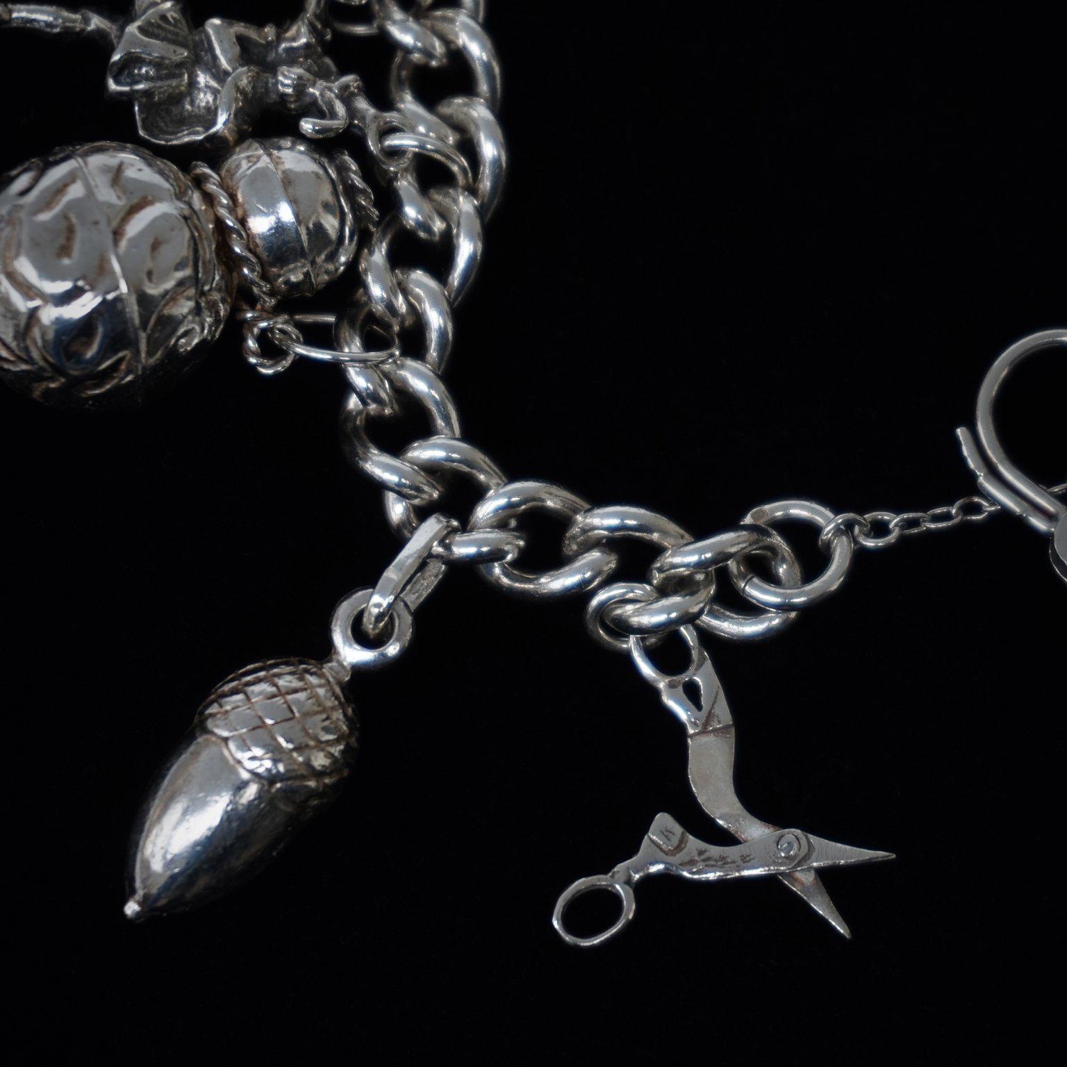 1950er Jahre Sterling Silber Englisch Vorhängeschloss Charm Armband mit siebzehn Charme im Zustand „Gut“ im Angebot in Haarlem, NL