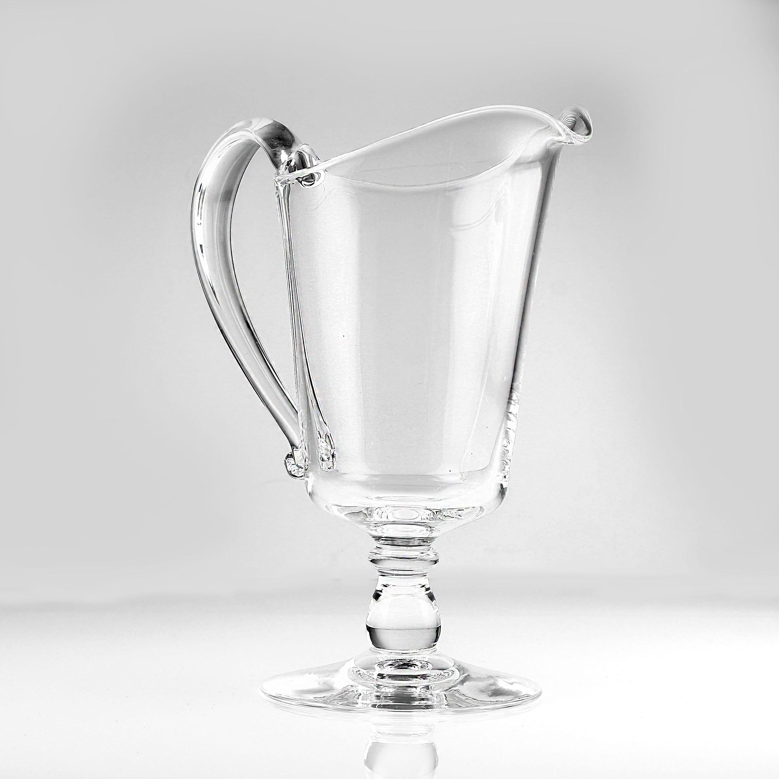 Steuben Glass soffiato a mano, brocca di crema con piede Eleg

Questa raffinata brocca in vetro soffiato a mano di Steuben Glass incarna l'eleganza moderna della metà del secolo. Con un'altezza di 6,5 pollici, il suo grazioso design con piedini e i