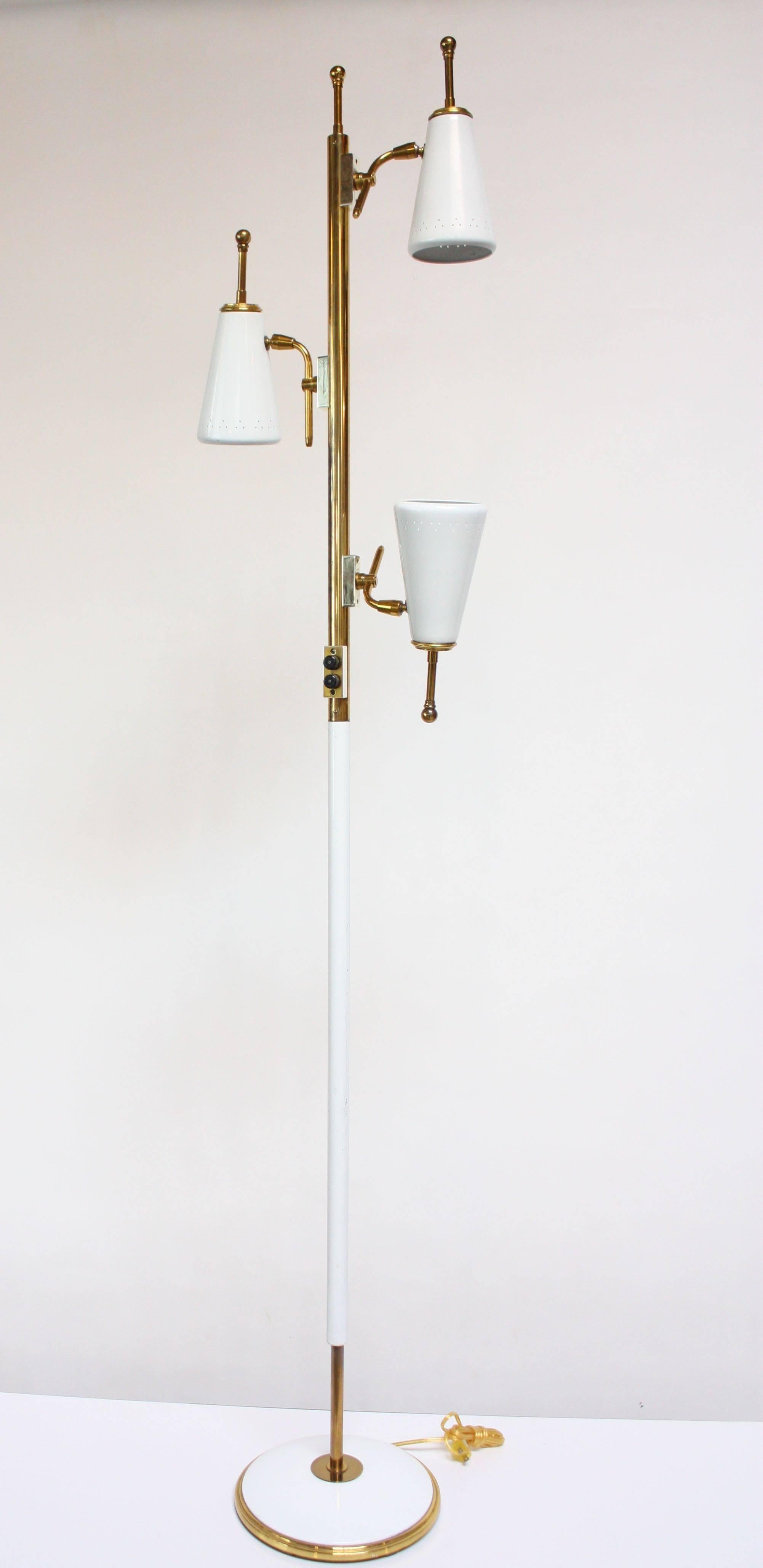 1950s Stiffel three-fixture adjustable floor lamp composed of a brass and painted metal tubular stem and three painted / perforated metal shades on a round base. Three illumination settings. Shades are fully adjustable; height is not.
Excellent,