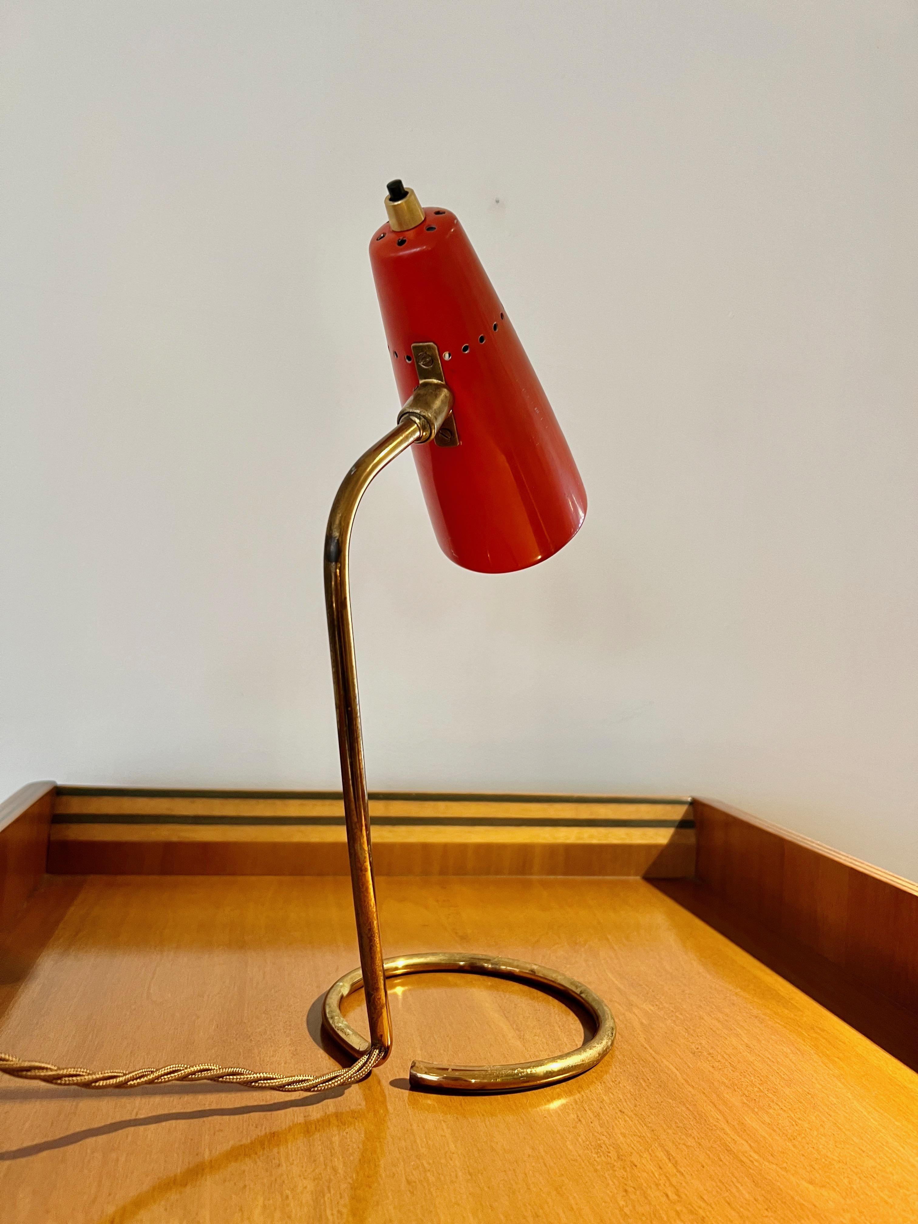 A charming 1950s small desk lamp by Stilnovo, Milan, with a pivoting 'shade' in brick red enamelled metal, on brass slender tube support.
Re-wired to UK safety standard.

With Stilnovo Milano Italy label.