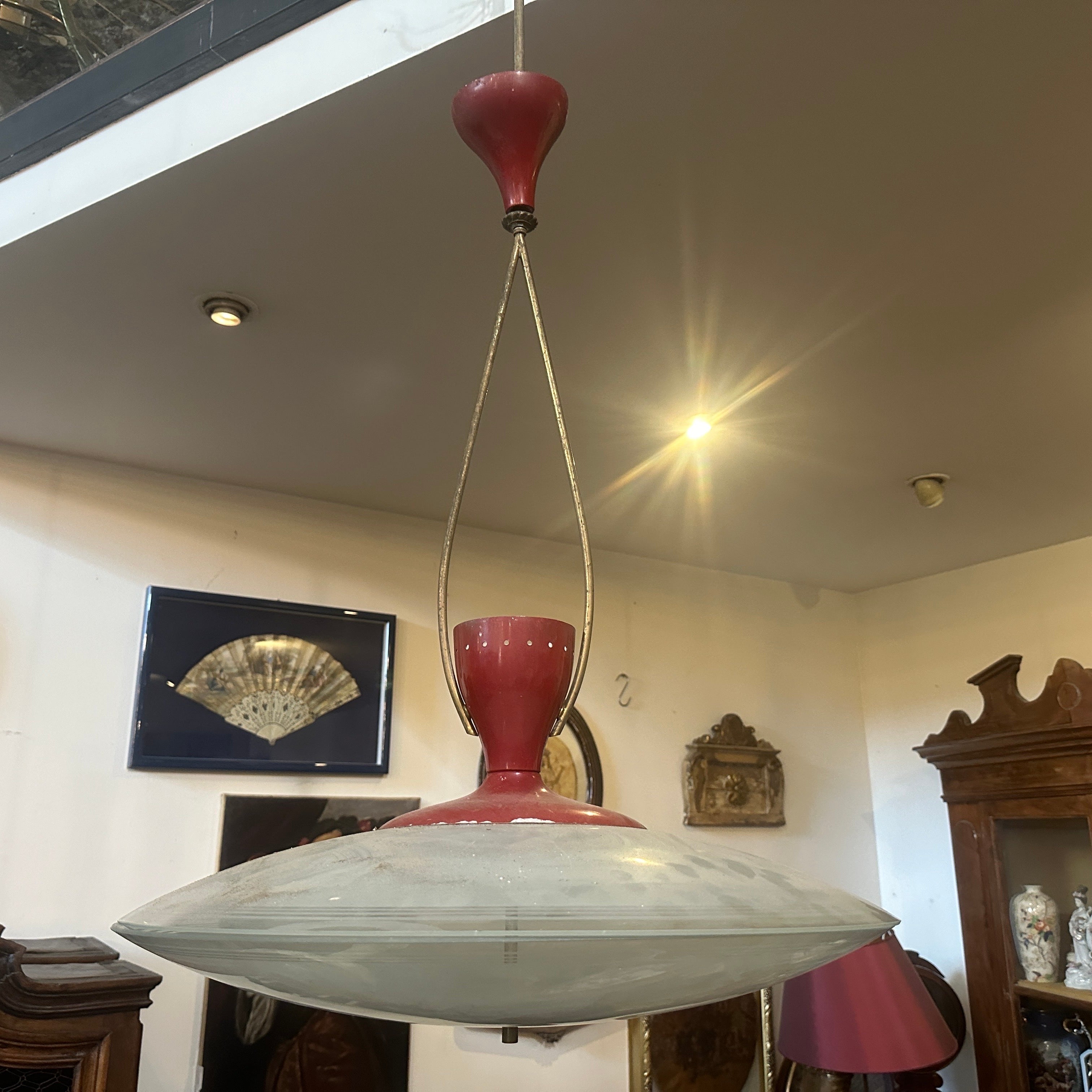 A large brass, red painted aluminum and glass pendant designed and manufactured in Italy probably by Stilnovo, it has normal signs of use and age, it's in original conditions, brass parts are in original patina, red aluminum has normal signs of age,