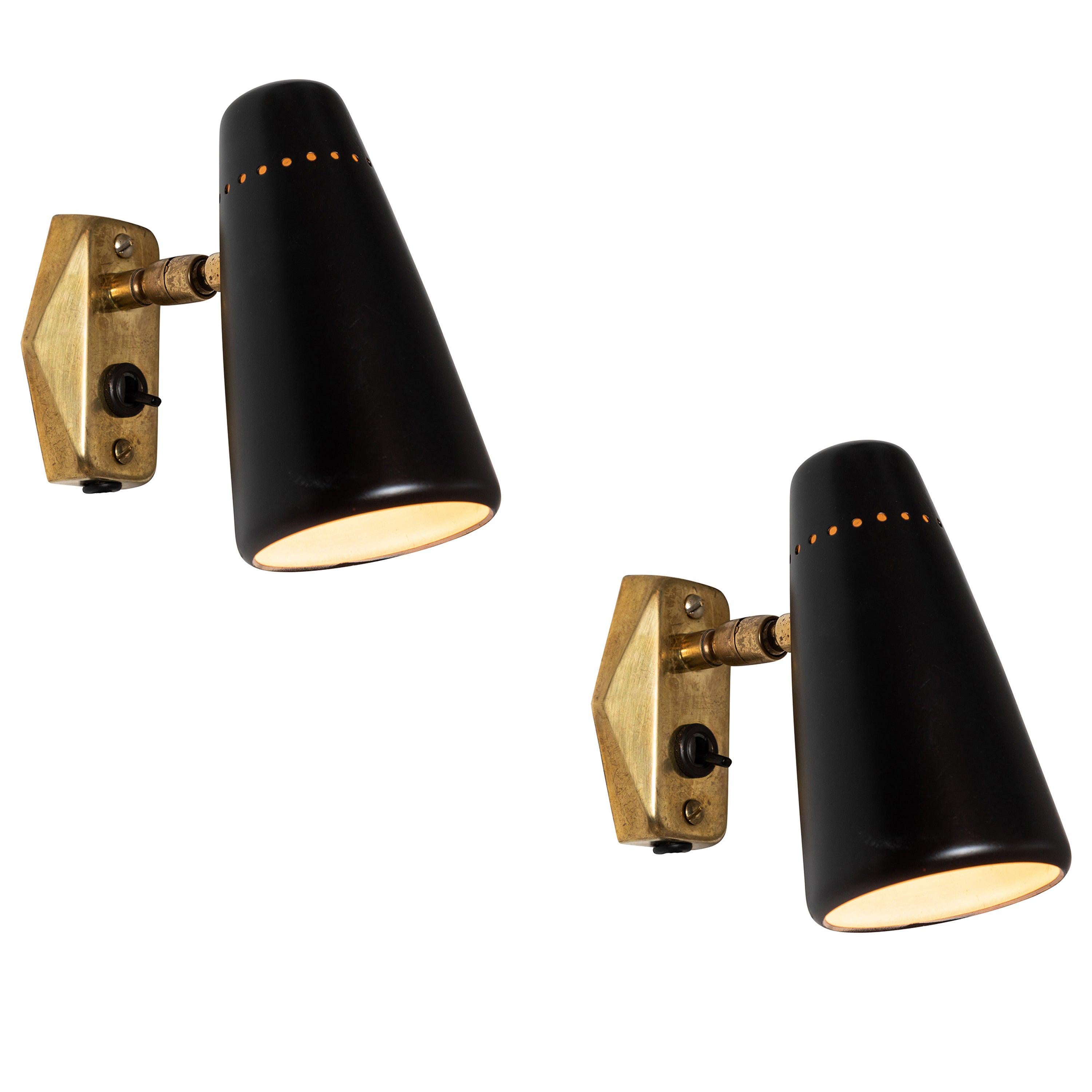 1950s Stilnovo black and brass wall light. A quintessentially 1950s Italian design executed in black painted metal with original Italian backplates, black cloth cord and US period styled wall plug. Shades can be rotated freely on a brass ball joint.