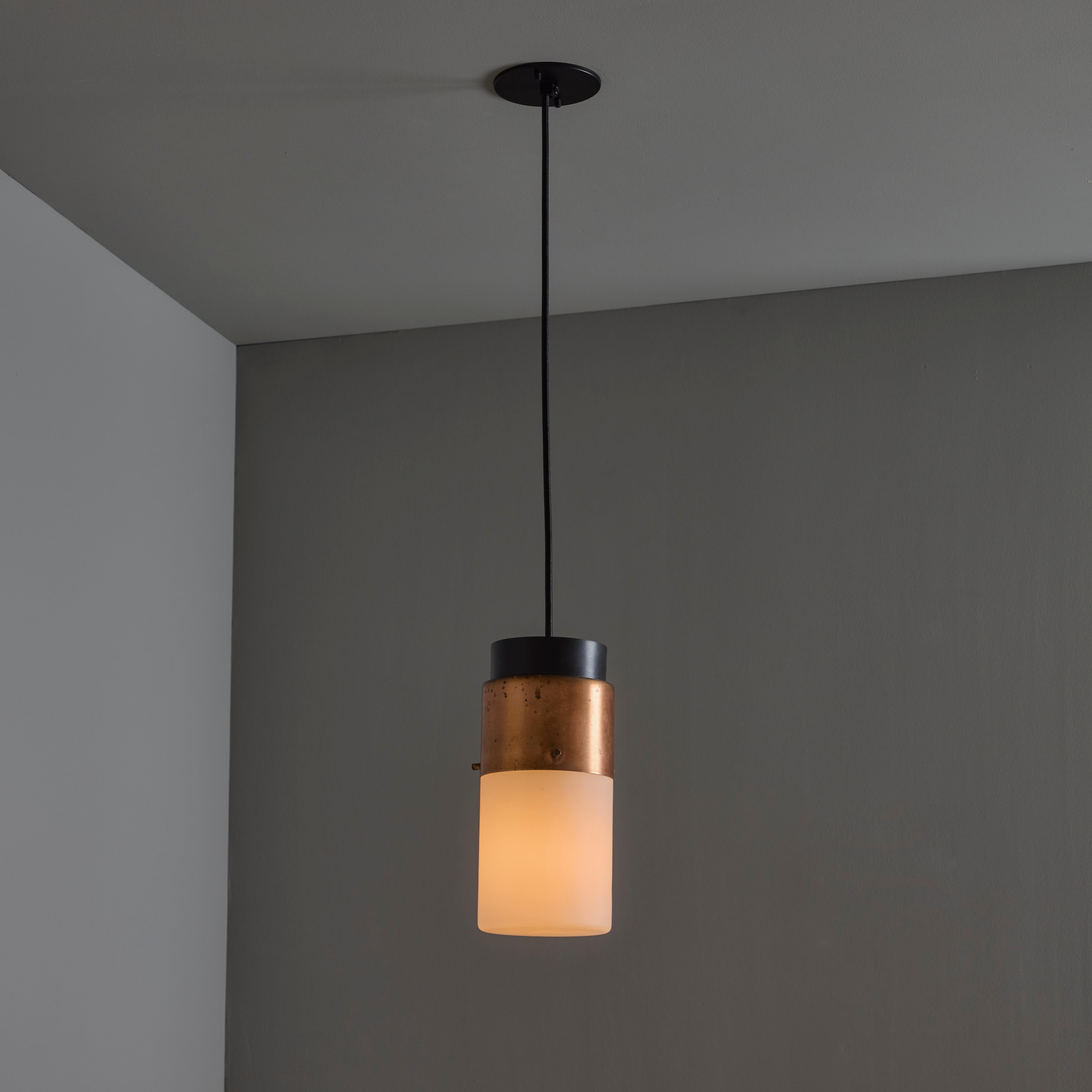 1950s Stilnovo Glass & Copper Cylindrical Pendant with Original Yellow Label.

Executed in sculptural cylindrical opaline glass with copper and black painted metal hardware. A highly refined ceiling lamp light of attractive scale and incomparable