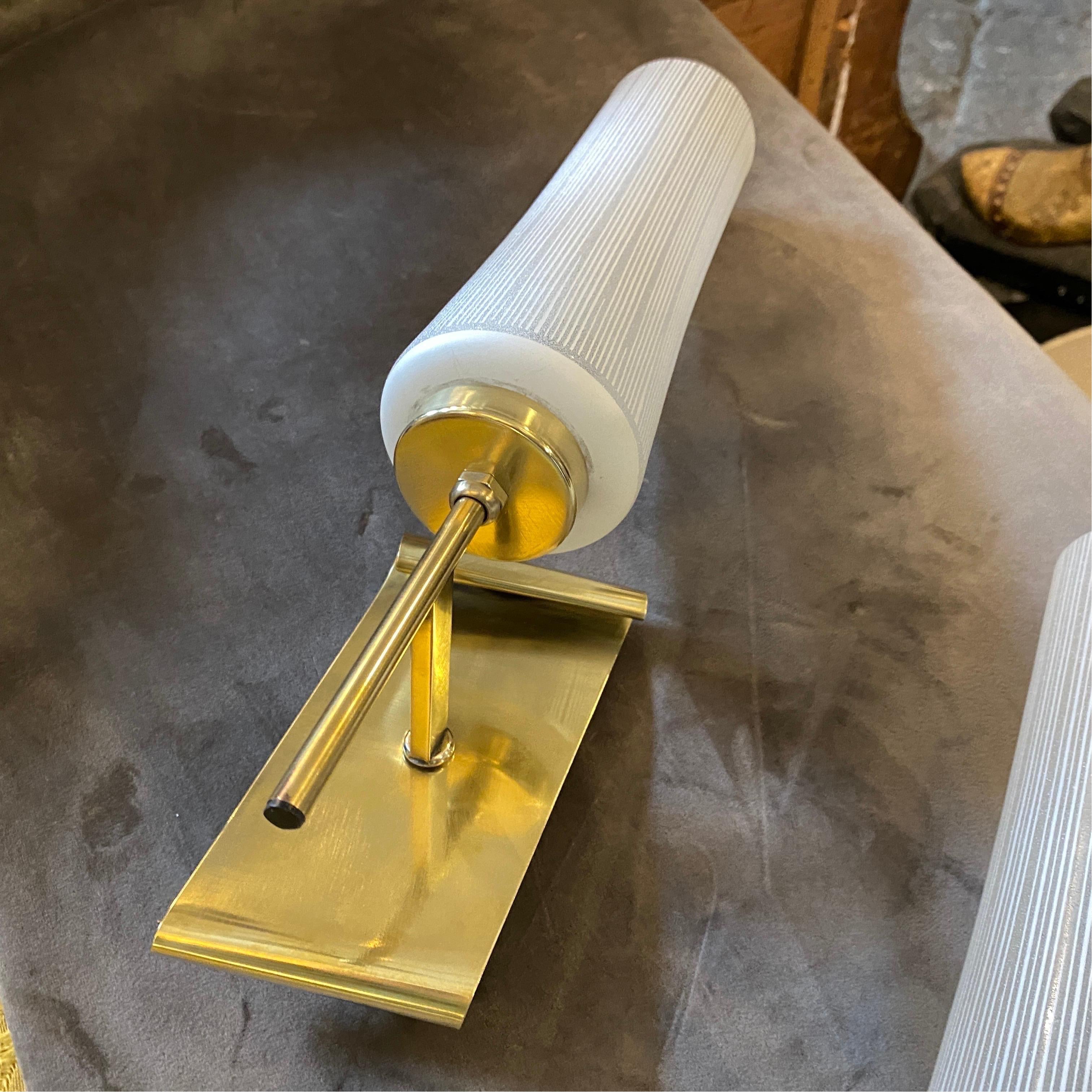 Two striped white glass and brass wall sconces made in Italy in the fifties, they are in very good conditions, work 110-240 volts and need regular e14 bulbs.
