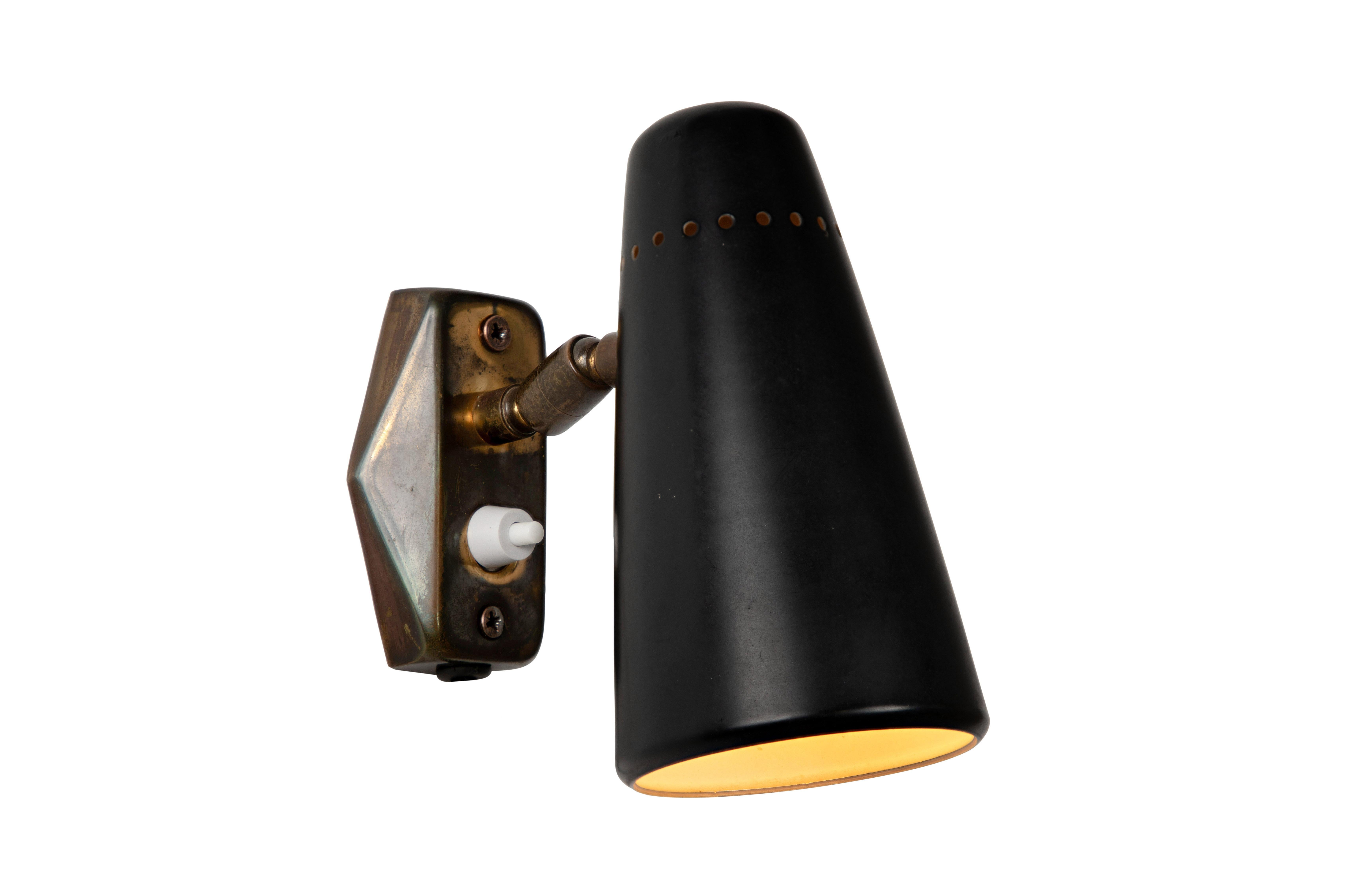 1950s Stilnovo wall light in black and brass. A quintessentially 1950s Italian design executed in black painted metal with original brass backplate. Shade can be rotated freely on a brass ball joint.

One lamp available in this