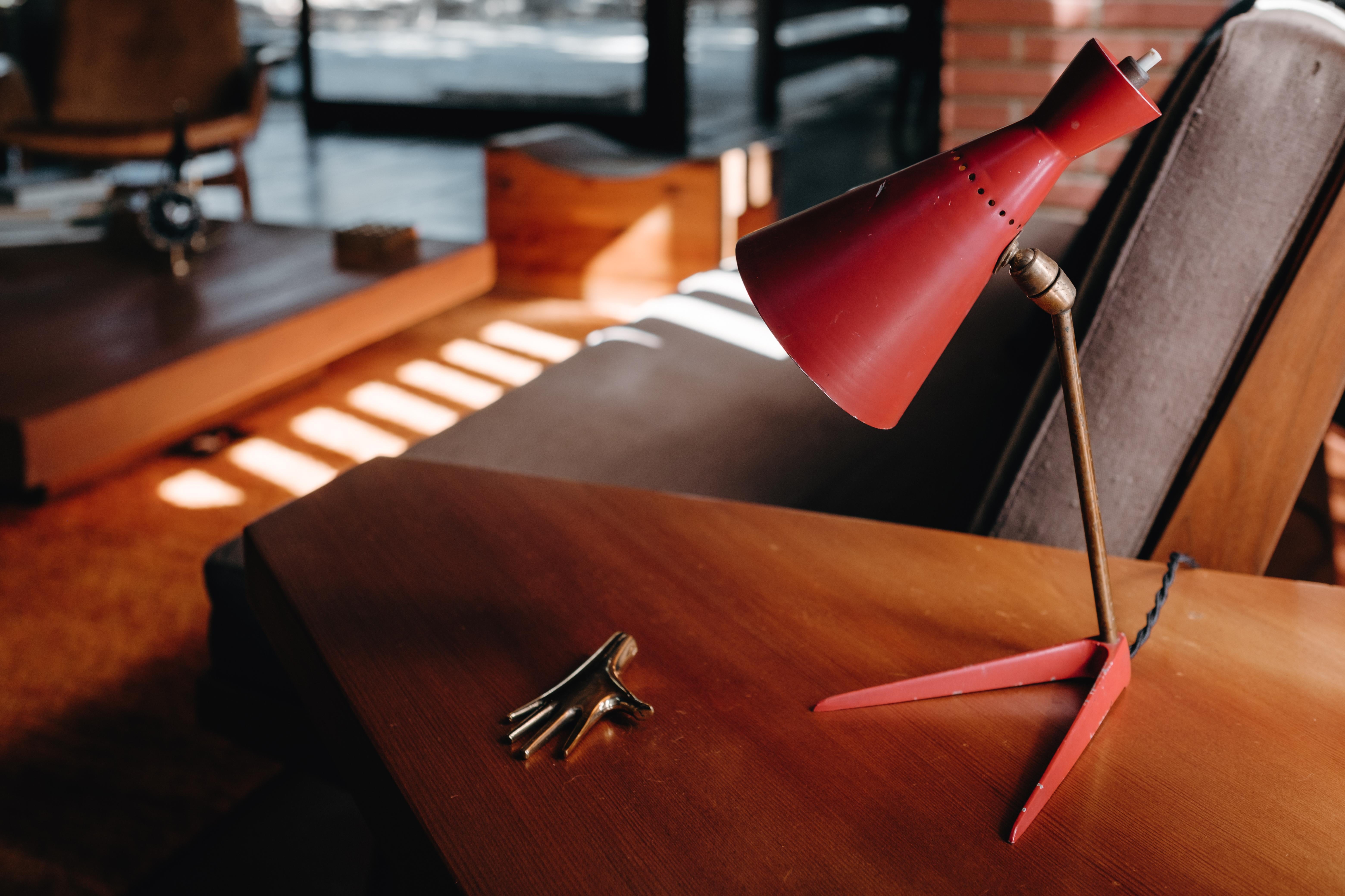 1950er Stilux Milano Tischlampe aus rotem Metall und Holz. Ausgeführt in rot lackiertem Holz, Metall und Messing. An zwei Punkten verstellbarer Schirm für eine flexible Vielfalt an Beleuchtungsmöglichkeiten.

Stilux war in der Mitte des Jahrhunderts