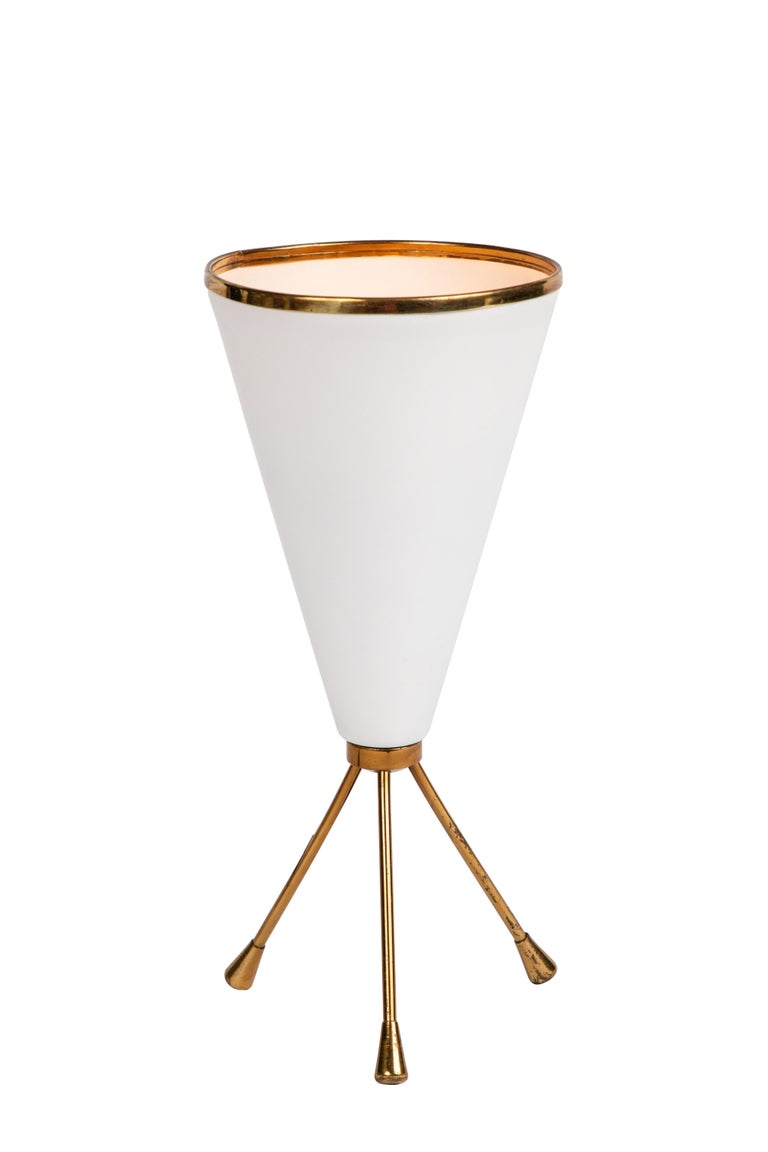 1950s tripod table lamp in white and brass attributed to Stilnovo. This elegantly sculptural table lamp is characteristic of the highly refined Italian lighting design aesthetics of the midcentury era as embodied by the legendary firm of