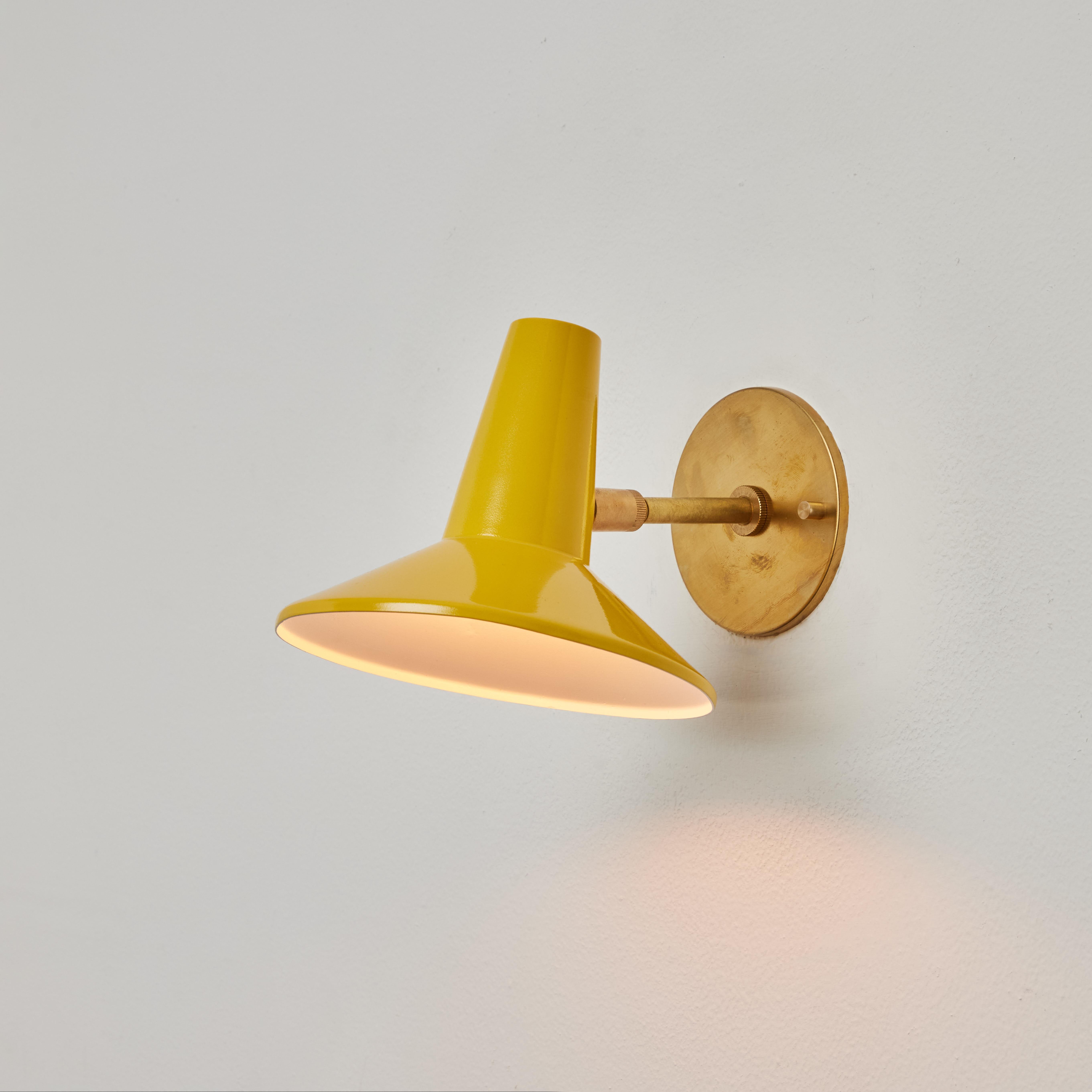 1950s Stilux Yellow Metal and Brass Articulating Sconce. Executed in brass and yellow painted aluminum. This highly adjustable wall lamp pivots up/down and left/right on a double ball joint. 

Stilux was one of the most innovative lighting design