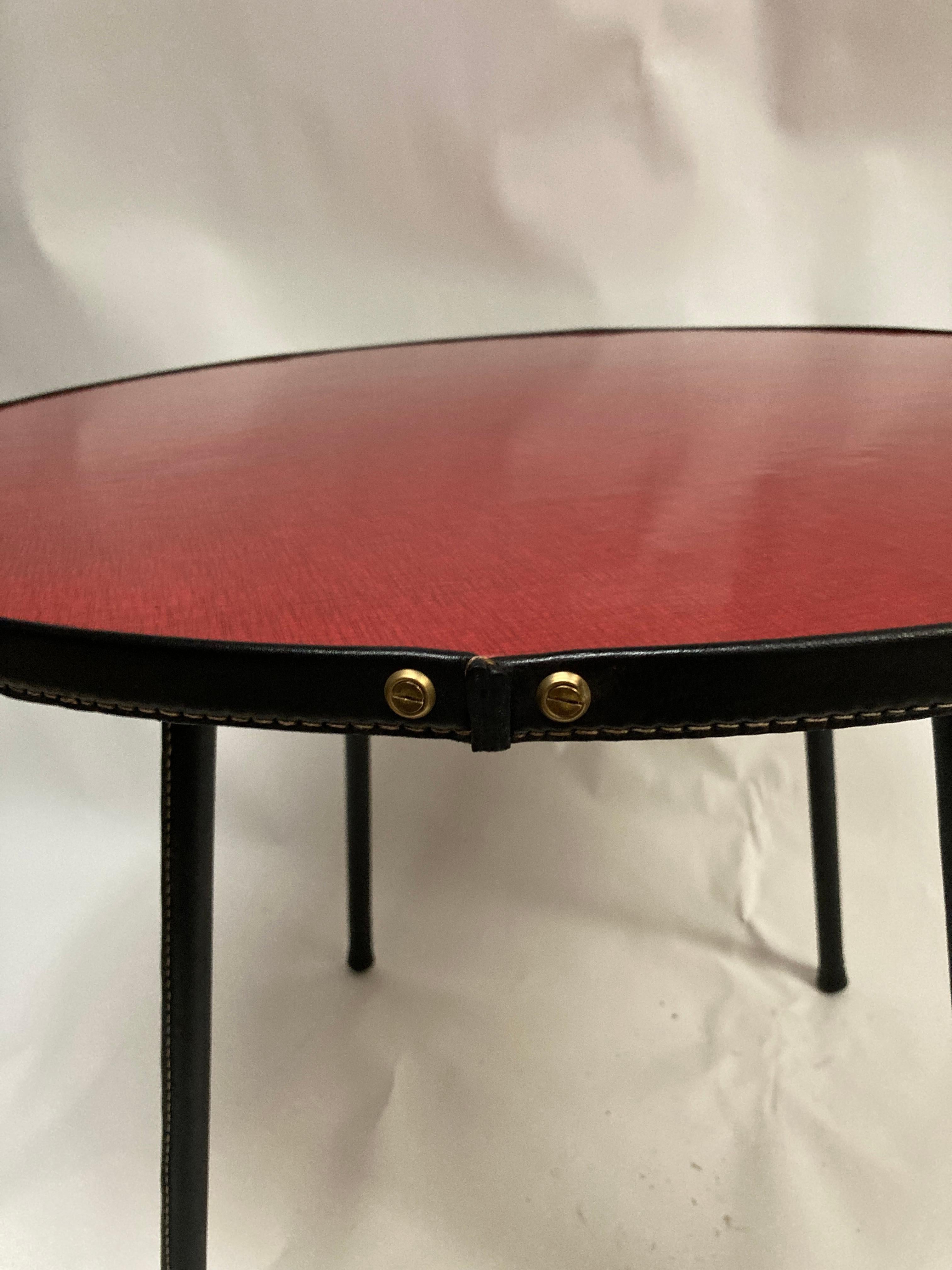 Very nice stitched leather table with red formica top
Black leather feet 
BY Jacques Adnet
France
