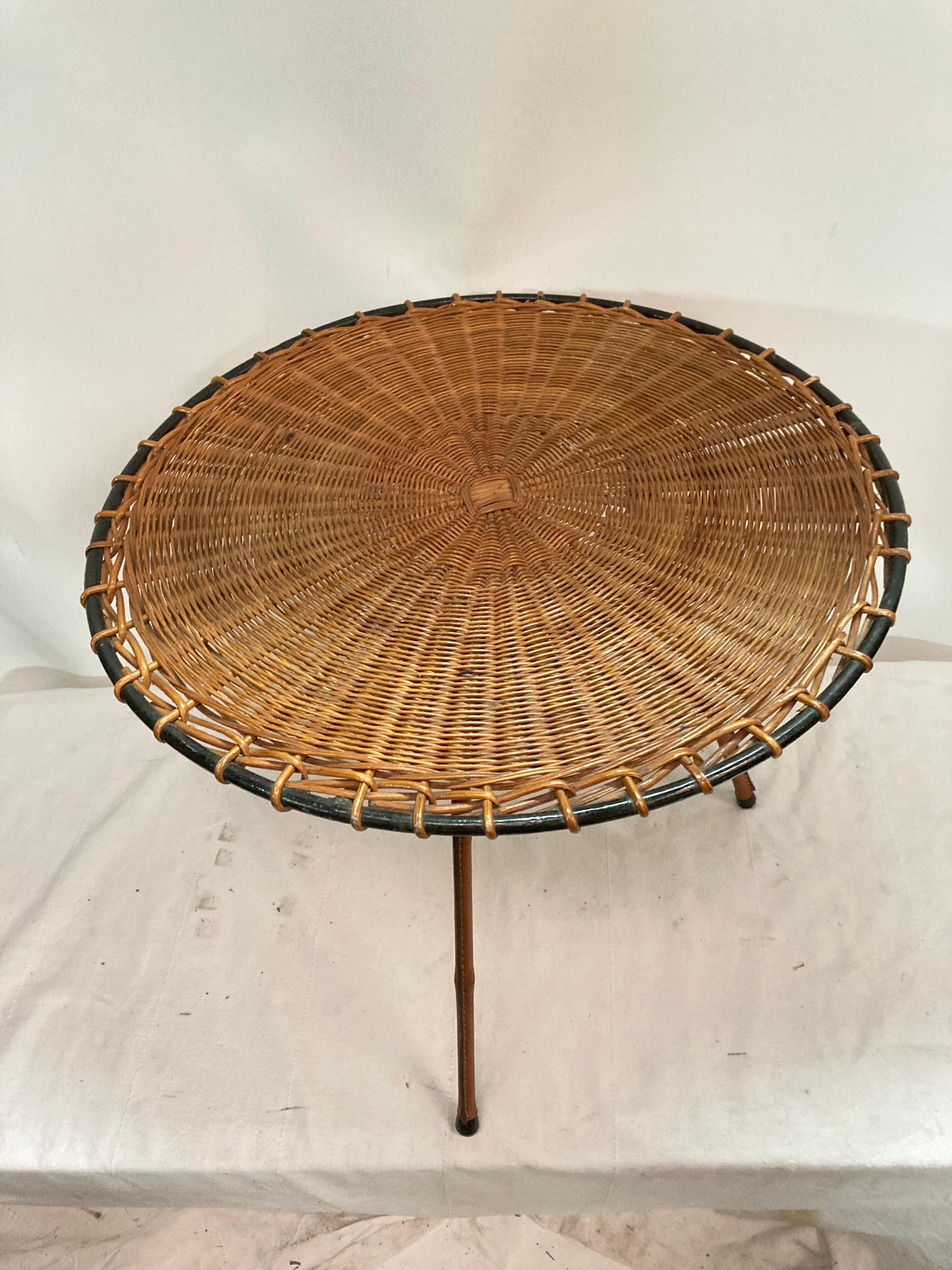 Très belle table d'appoint avec plateau en rotin et pieds en cuir surpiqué dans le style bambou.
France
1950's