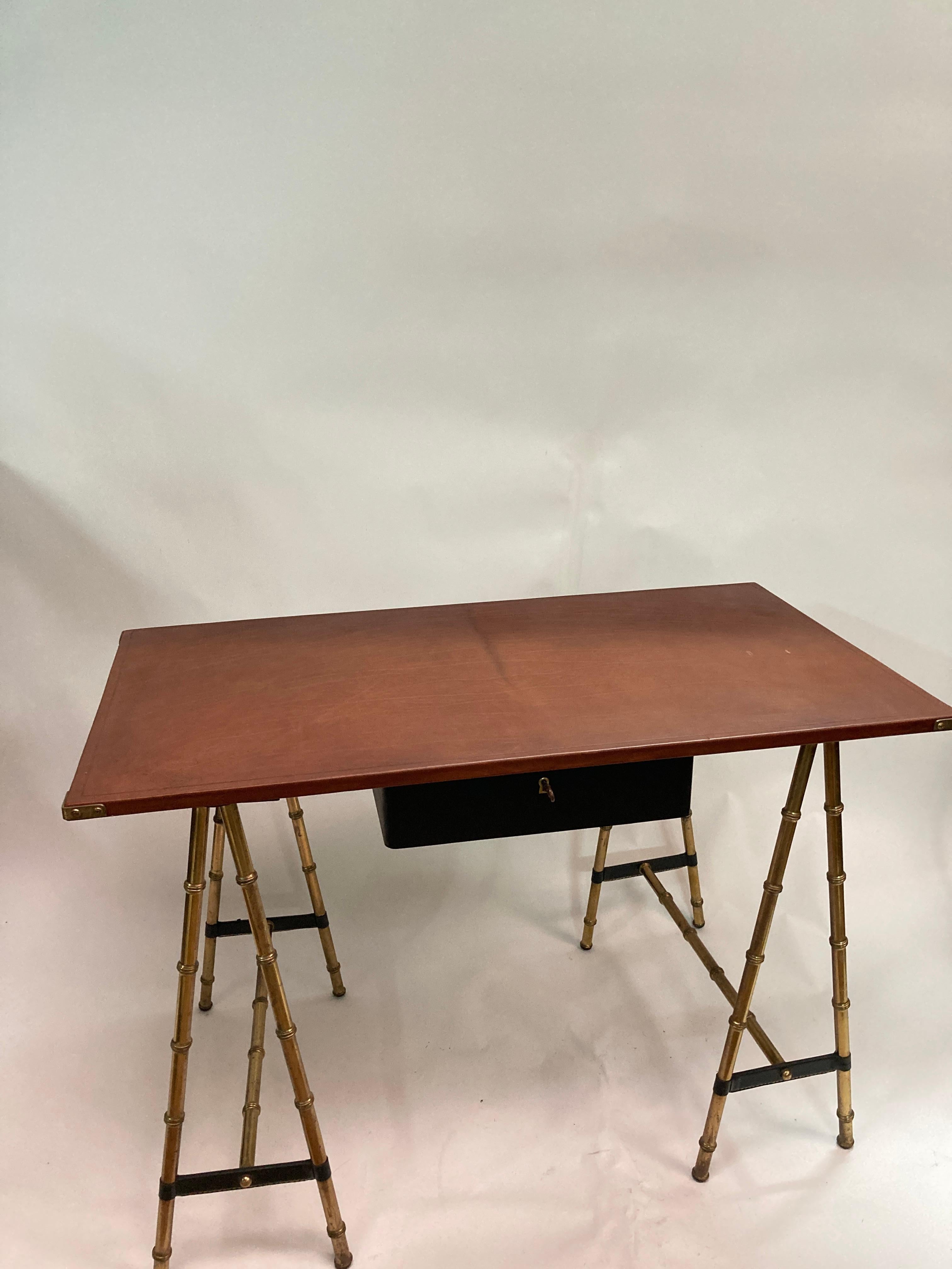 Très beau bureau en cuir surpiqué bicolore marron et noir 
pieds en laiton à la manière des bambous 
Possibilité d'ajouter un fauteuil qui n'est pas inclus