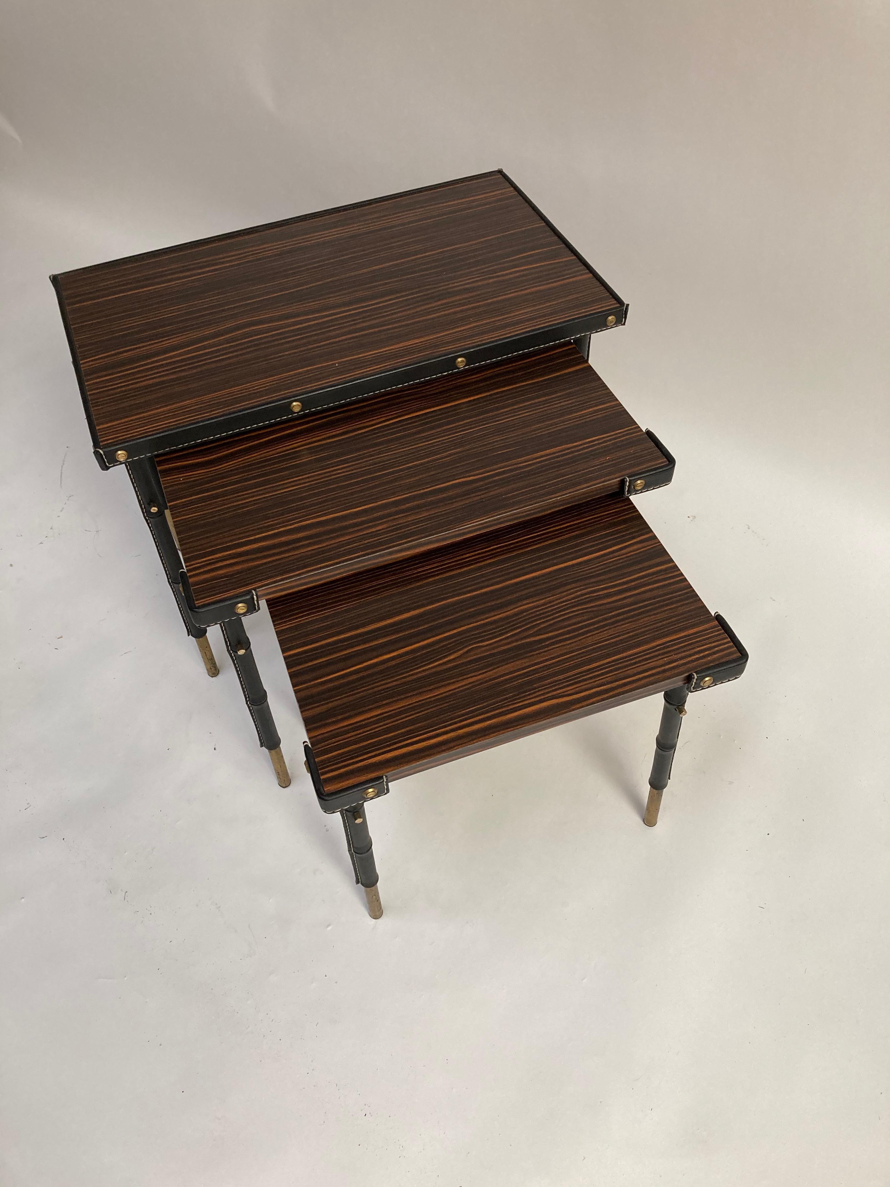 tables gigognes en cuir surpiqué des années 1950 par Jacques Adnet
Très bon état
France
Dimensions : 62 x 37 x 48
52 x 37 x 44 
37 x 42 x 40 cm.