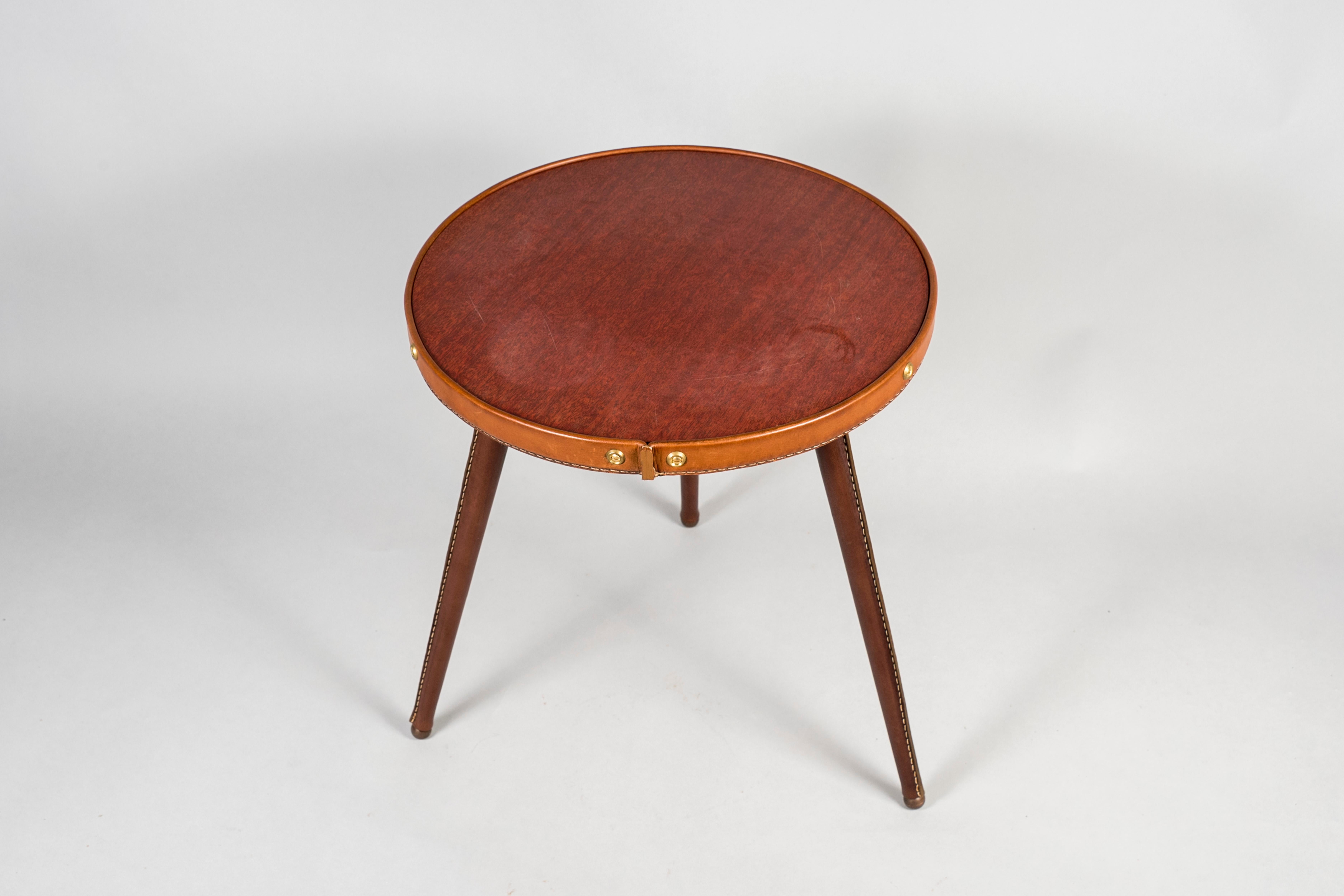 Very nice small table covered with stitched leather.
Top with brown formica.
Designed by Jacques Adnet.
France.