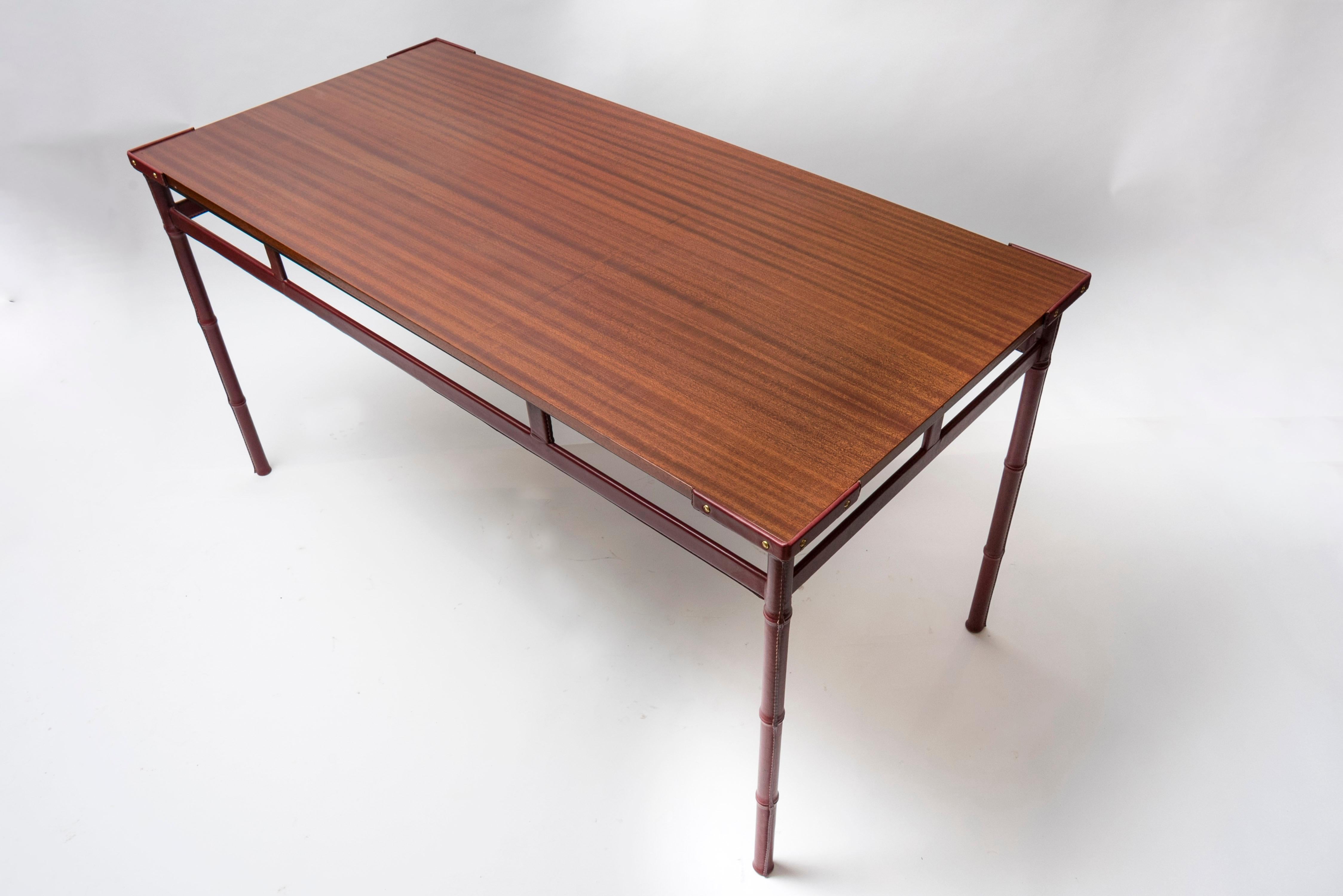 Petite table à manger ou écritoire en cuir surpiqué des années 50 par Jacques Adnet
Cuir de vache et bois de poirier contaminé

