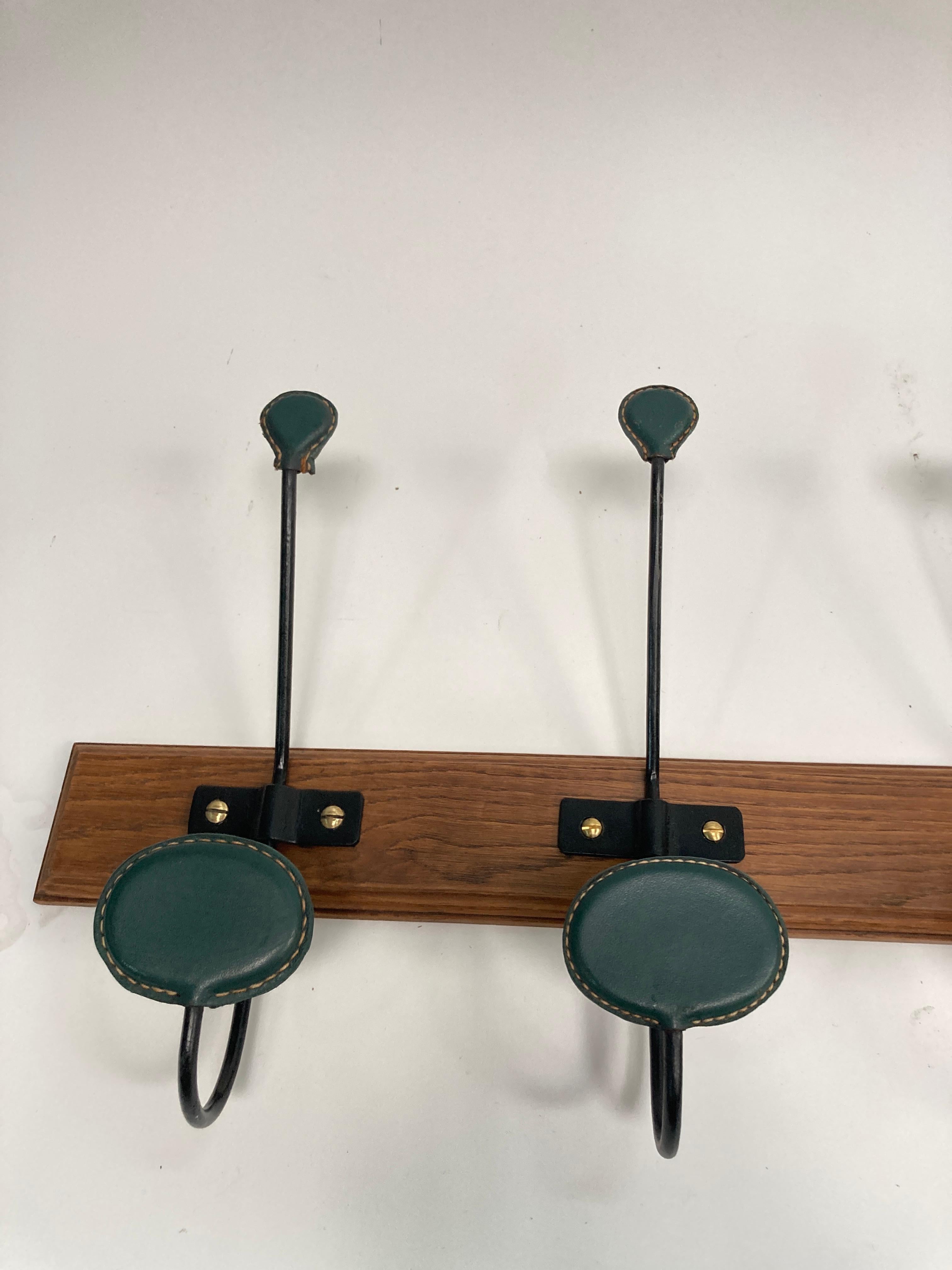 Rare large Stitched leather coat rack  by Jacques Adnet
Very rare long like this with 8 pieces
Great condition
Dark green leather