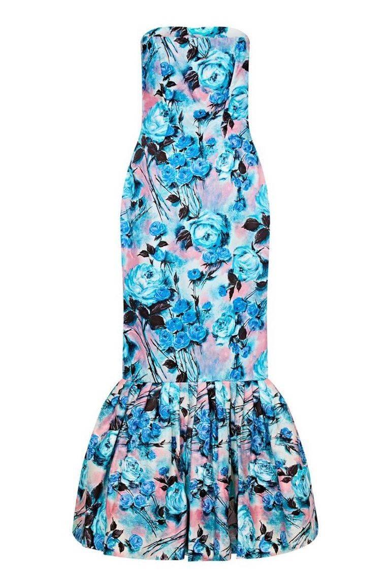 This show-stopping 1950s floral strapless dress with fishtail hem is designed to turn heads. The rose print design is in a man-made sateen type fabric of electric blue, navy and dusky pink.  Coupled with the incredible construction, the simple