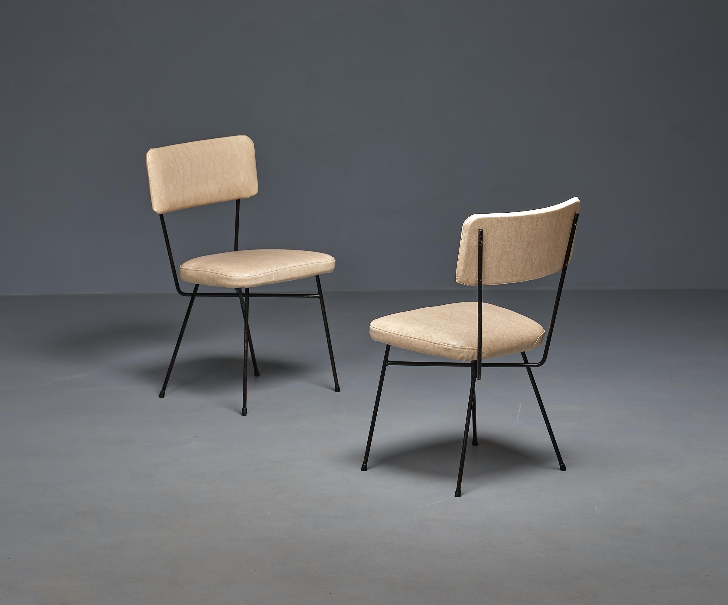 Introducing a captivating pair of vintage chairs from the 1950s, These chairs are a beautiful nod to mid-century Italian design.

With their sturdy black-painted iron frames, these chairs exude a timeless appeal. They feature elegant Skai upholstery