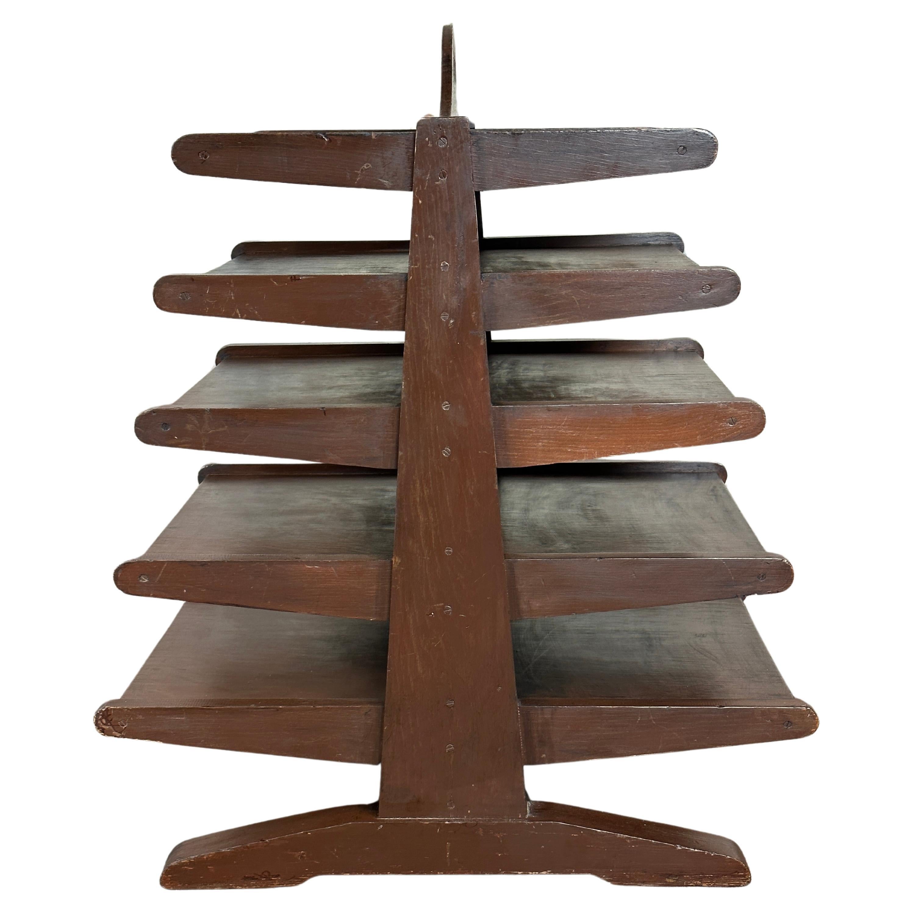 This is a The 1950s Studio Craft Magazine Tree embodies the DIY Dunbar style, reminiscent of the iconic designs by Edward Wormley. This rustic piece stands proud in its original dark walnut stained wax finish, capturing the essence of the era. This