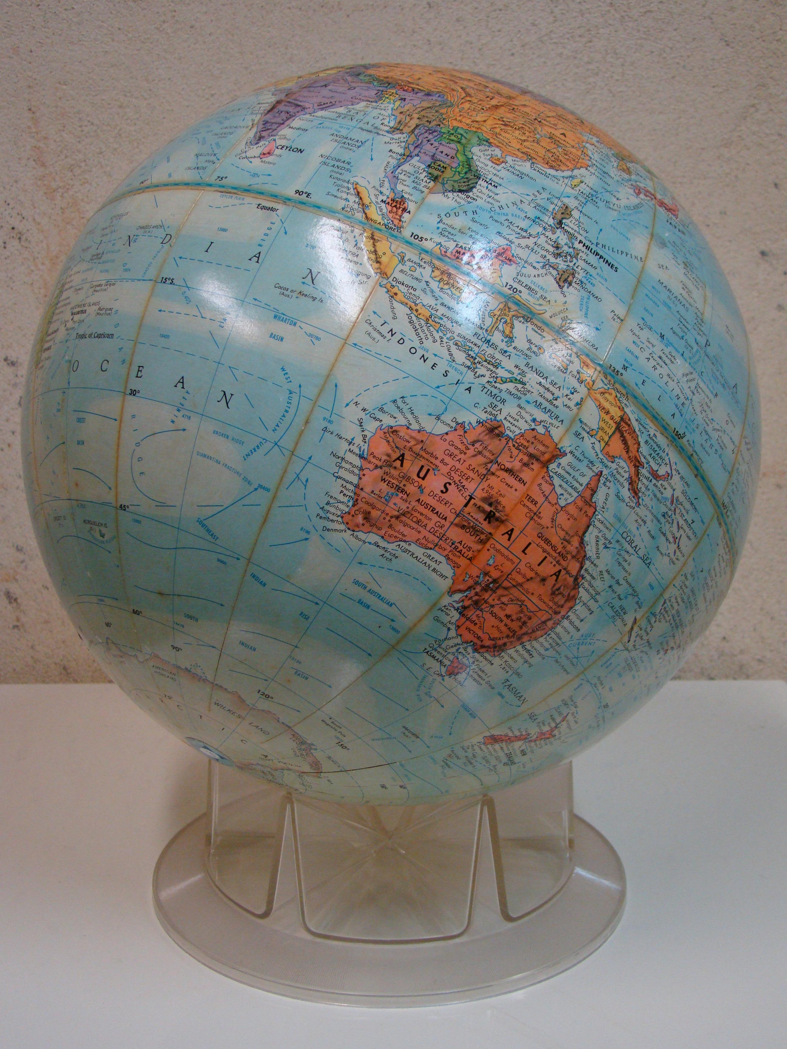 The beautifully placed colors and subtle topographical texture in this cardboard core and printed paper globe set it apart from many. This will quickly become your favorite. Simple in design, the free floating globe is cradled by a clear, plastic