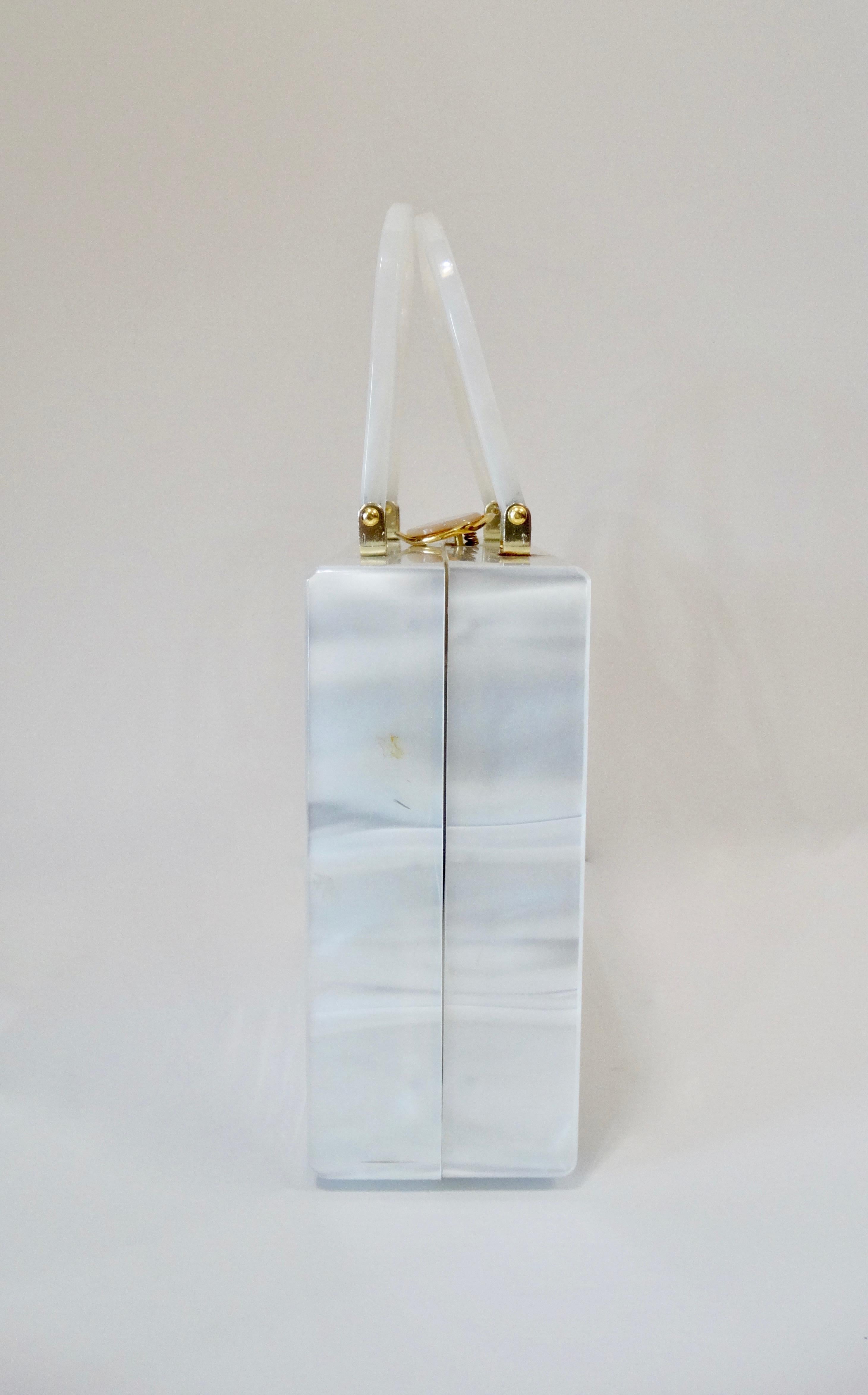 Carry around a piece of the 50's with you with this amazing box bag! Made by Stylecraft Miami, an innovative bag company that produced bags in a variety of styles and materials, this bag is a narrow box shape and is made of pearly white Lucite.
