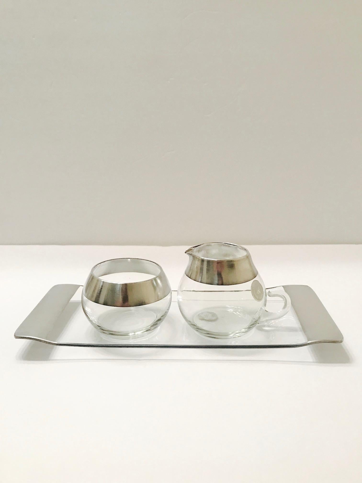 Rare Mid-Century Modern blown glass sugar and creamer set with the iconic sterling silver overlay design that Dorothy Thorpe is known for. Set includes creamer with spout and elegant blown glass handle, a streamline sugar bowl, and a gorgeous narrow