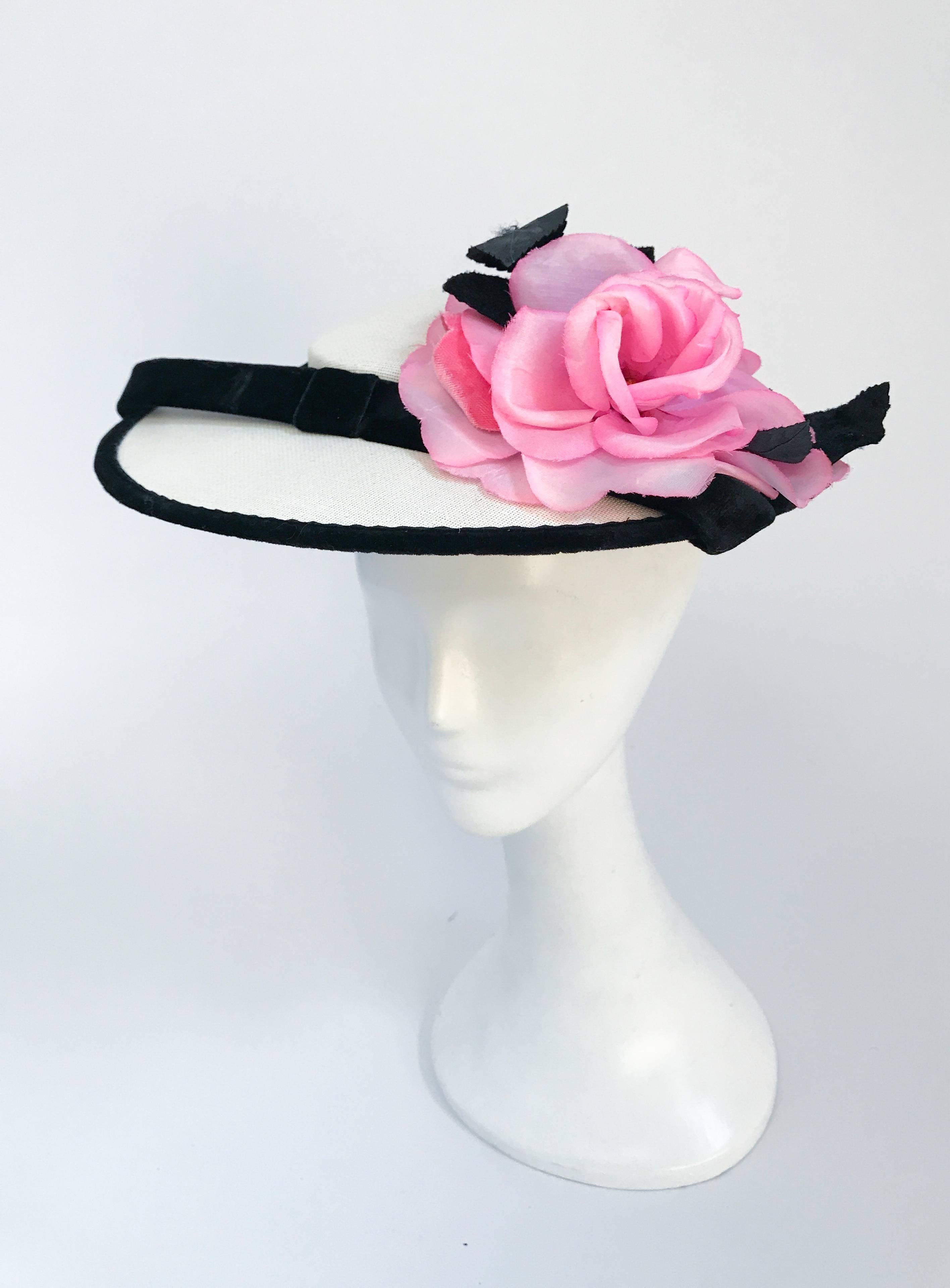1950s Sunhat with Black Velvet trim and Silk Flower. Sunhat with black velvet trim, band, and leaves. Features a pink silk flower. Side prongs to secure hat to head.                                                                                    